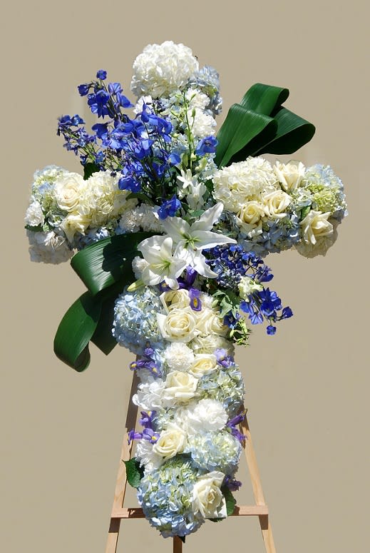 Heavenly Cross - A large cross full of blue and white hydrangeas, roses, carnations, lilies, lavender irises and blue delphinium. This cross is very lush and full of fresh flowers only. This arrangement can be ordered from