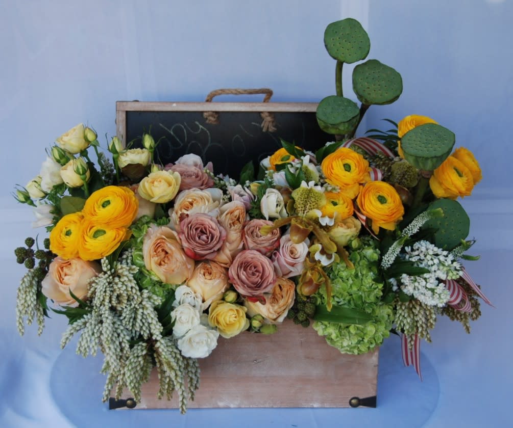 Lakeview Terrace CA Flowers - This is a lush arrangement in a vintage box with chalkboard lid. The box is fulled with seasonal flowers such as ranunculus, lilacs, garden roses, green hydrangeas, spray roses, lady shoe orchids, and lotus pods. . Would look fantastic in Lakeview Terrace