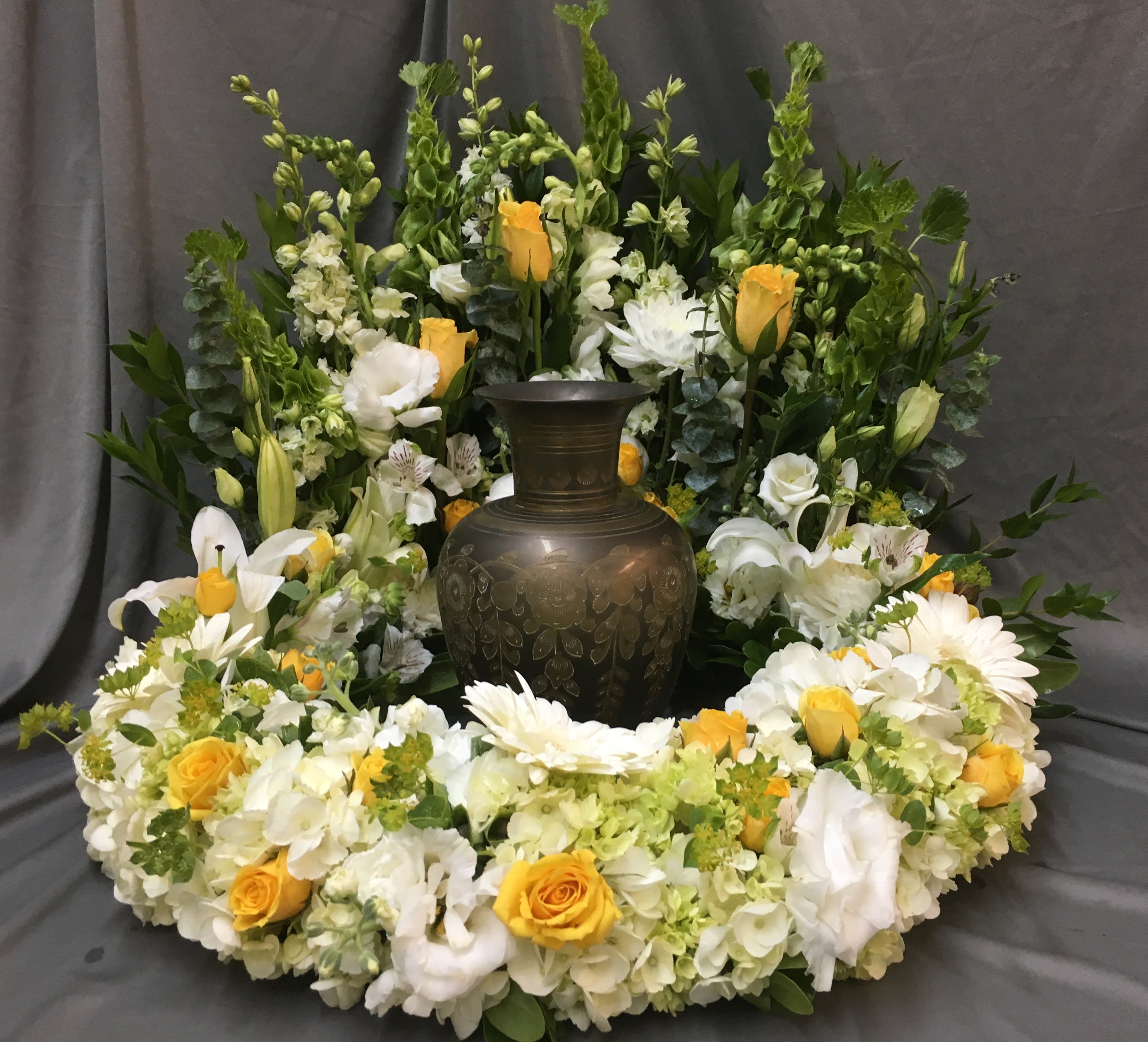 White, Green, and Yellow Eternal Wreath - Featuring White Hydrangea, Green Hydrangea, Bells of Ireland, White Gerber Daisies, White Hybrid Lilies, White Lisianthus, White Snap Dragons, Yellow Standard Roses, Yellow Spray Roses, White Stock, and Bupleurum.