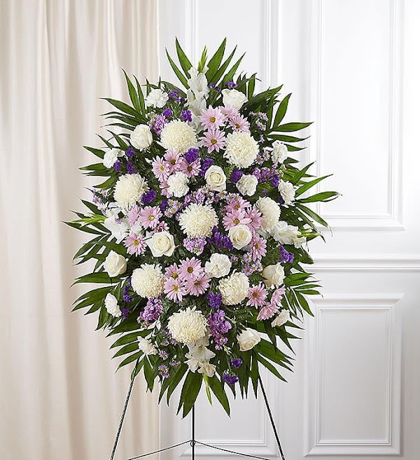 Lavender And White Funeral Standing Spray - When words alone cannot convey the feelings in your heart, flowers can provide a meaningful and profound statement. Our impressive standing spray arrangement is meticulously handcrafted by expert local florists with soothing lavender and white blooms for a lush, full presentation, presenting an elegant and memorable tribute.