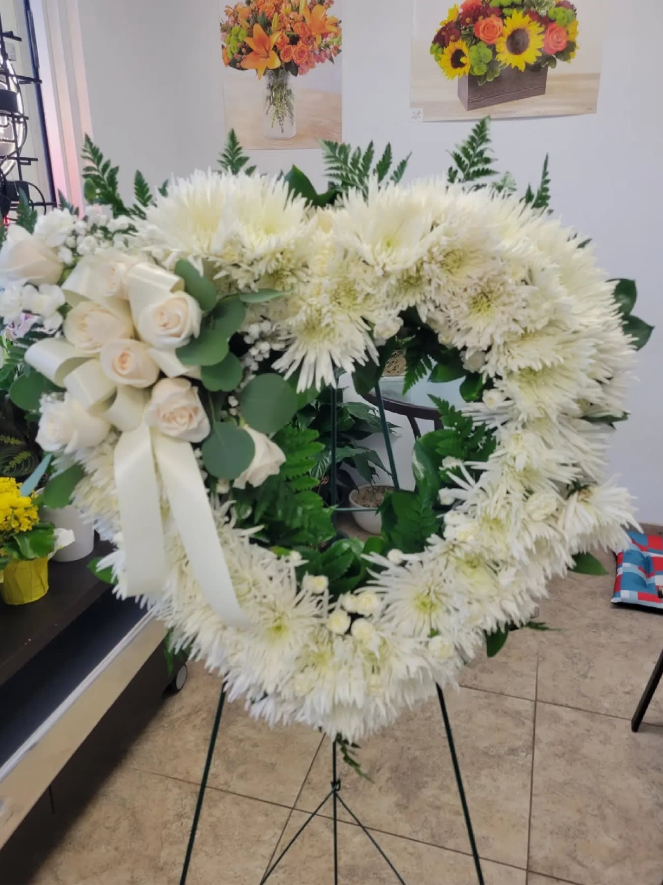 Love and Purity - An all white tribute, this heart shaped easel shows your everlasting love. Featuring a variety of white flowers and greenery.  Flowers and similar colors