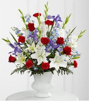  Cherished Farewell™ Arrangement - Cherished Farewell™ Arrangement is an elegant display of patriotic beauty to honor your loved one at their final farewell service. Red roses, red carnations, white gladiolus, light blue delphinium, blue iris, white Oriental lilies, white Asiatic lilies and lush greens are elegantly arranged in a white plastic urn to create a stunning way to say your last goodbye. GOOD arrangement includes 28 stems. Approximately 32&quot;H x 26&quot;W Your purchase includes a complimentary personalized gift message.