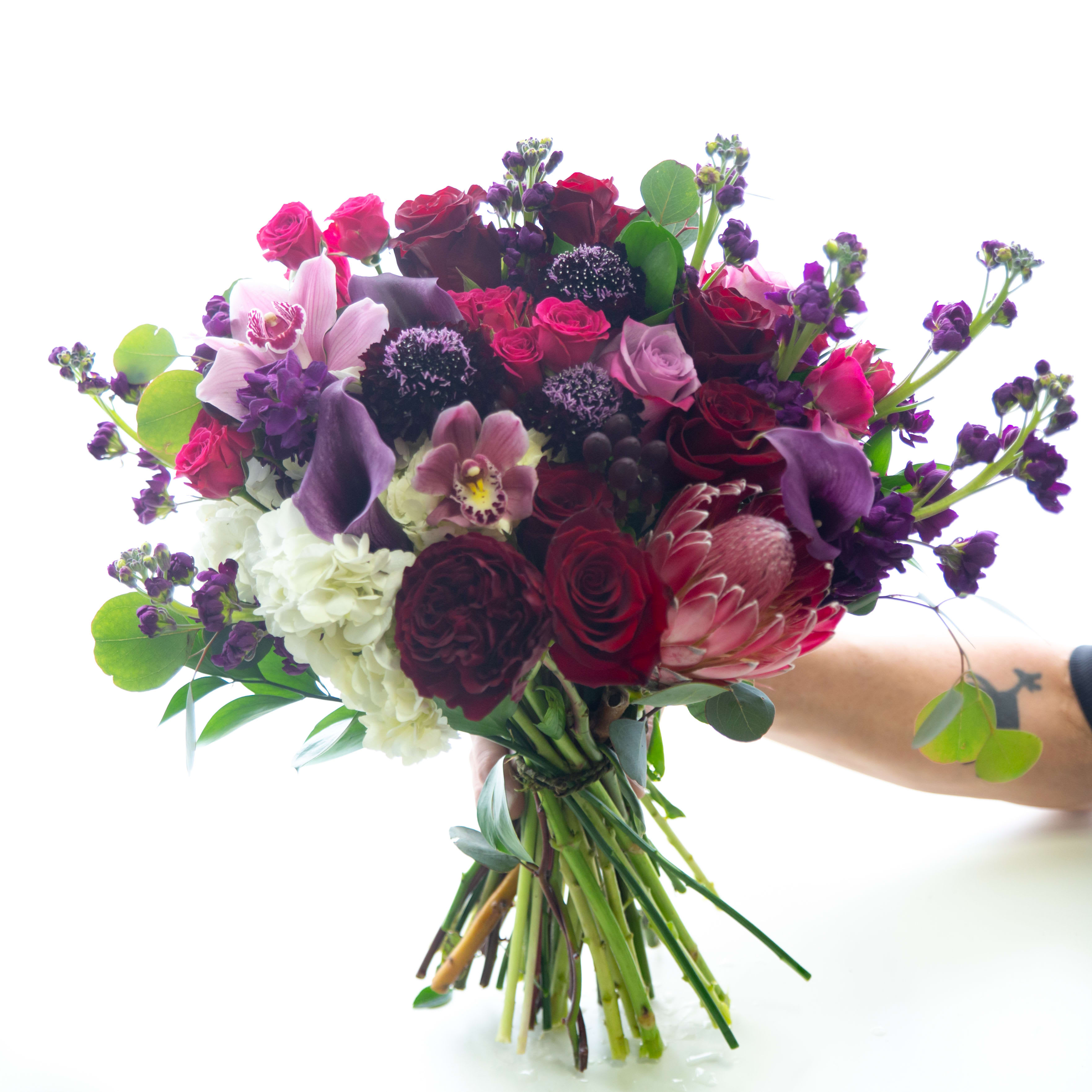 Lovers' Lane Bouquet  - Sultry bouquet of red, pink and purple toned flowers including roses, mini callas, orchids, pink proteas, purple stock and hot pink  spray roses 