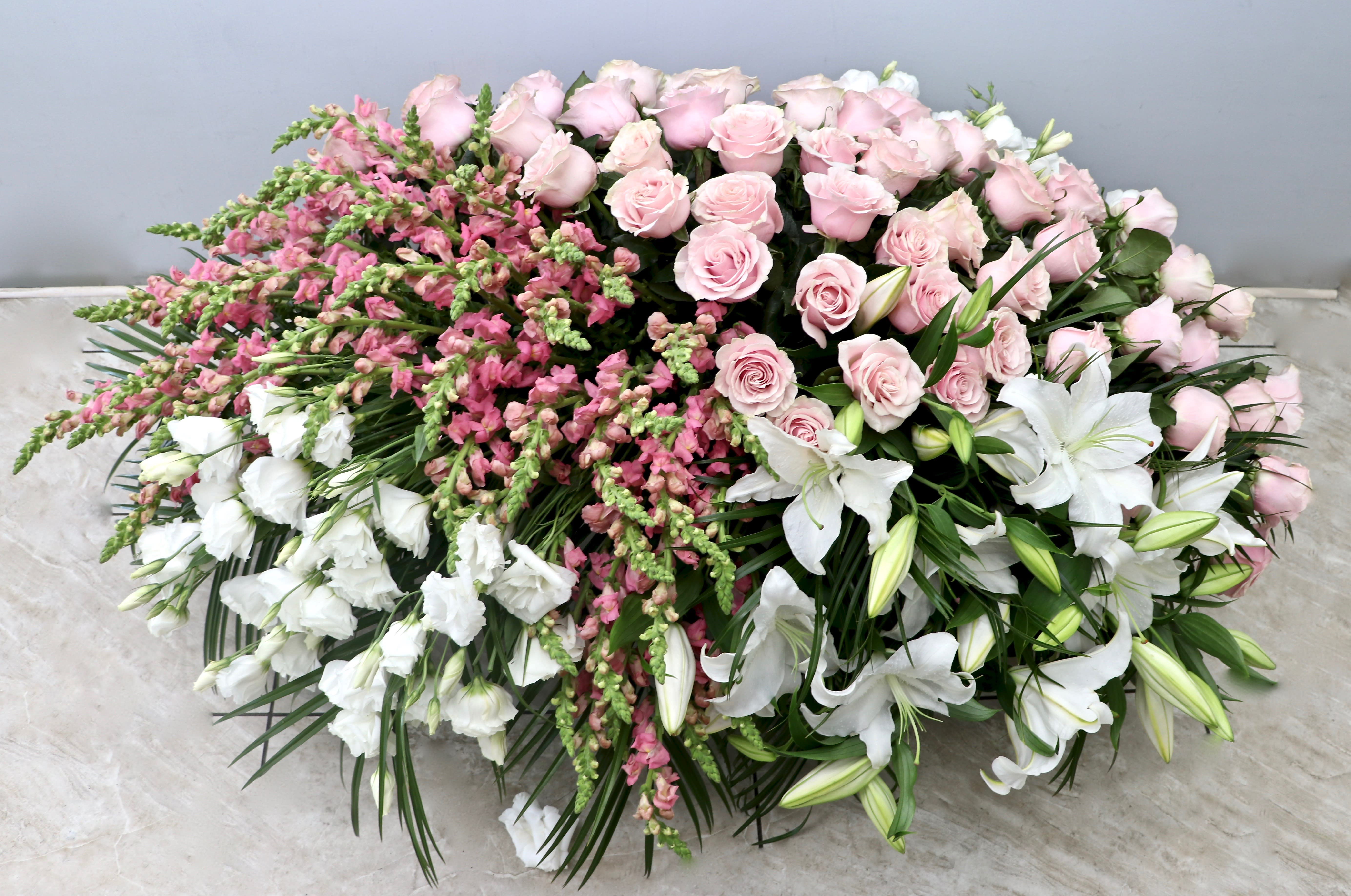 Pink Casket - My Glendale Florist  - This full casket spray includes pink roses, snap dragons, lisianthus and lilies. 
