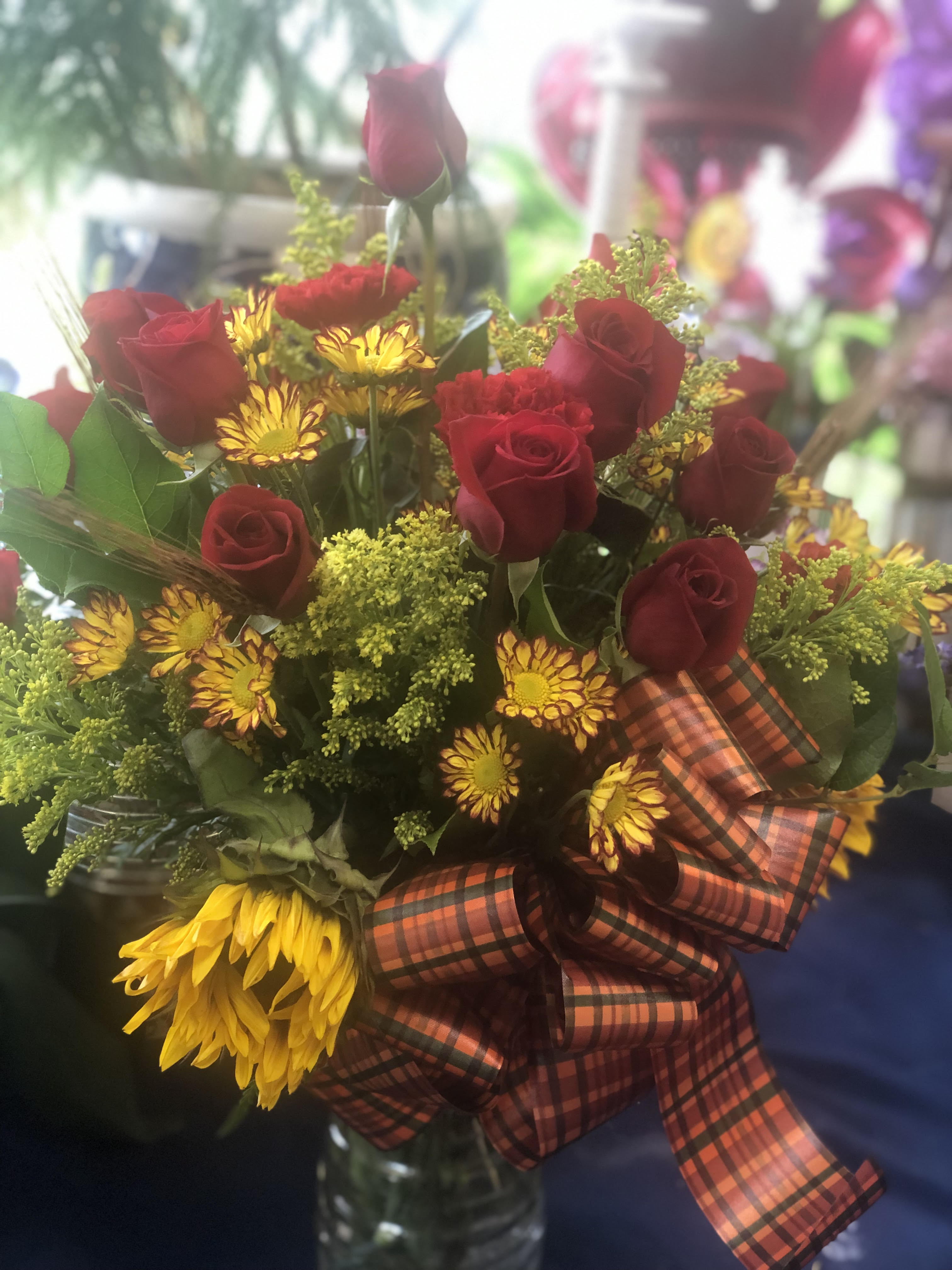 Fall In Love - It's easy to fall in love with the shades of autumn  - send a dozen roses plus other blooms and embellishment in the shades of fall in one of our glass vases to the one you love