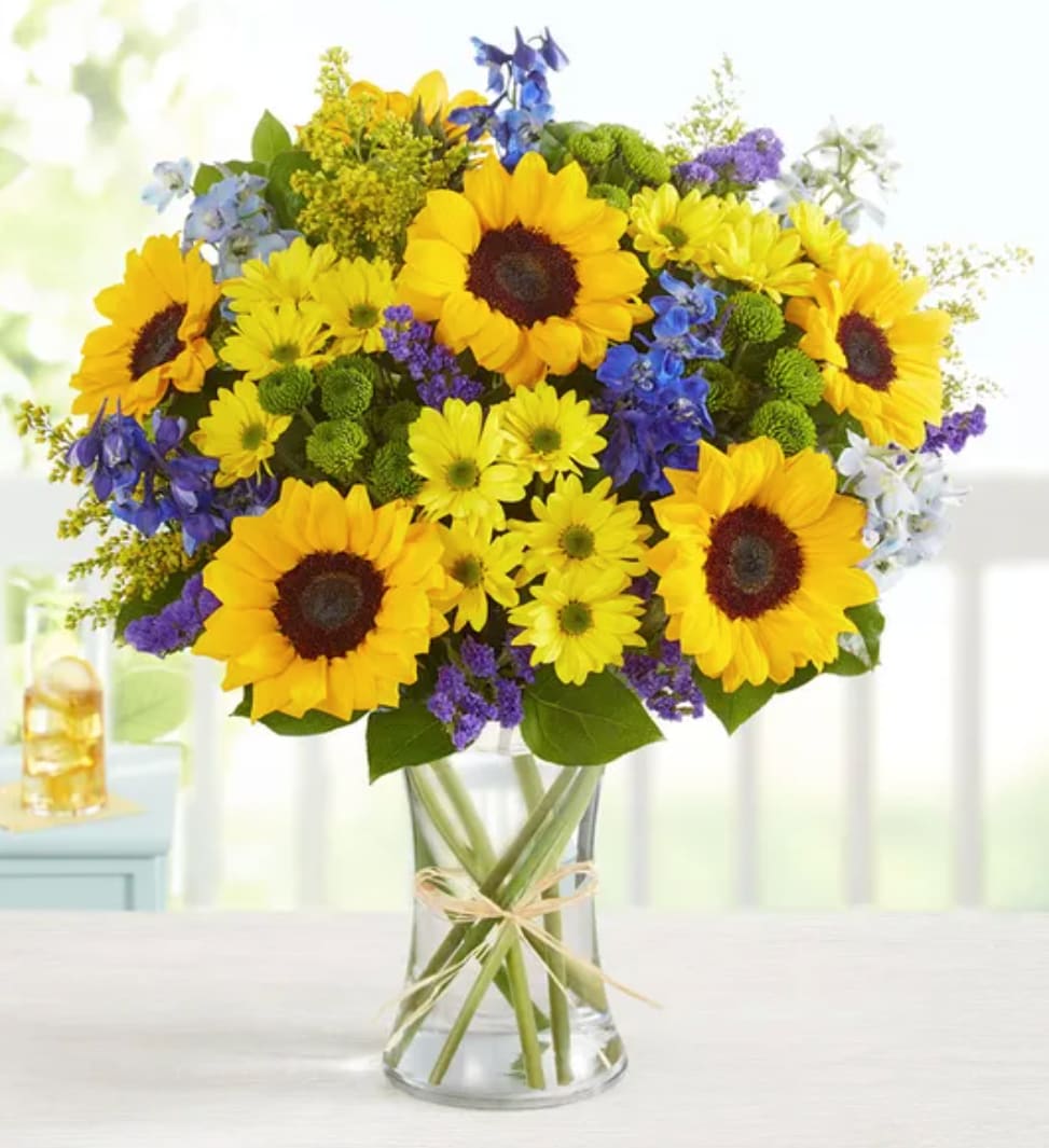 Fields Of Europe® Sunshine - Inspired by the colorful charm of the European countryside, our best-selling summer bouquet is gathered with fresh-picked blooms, revealing the rustic beauty of nature. Shades of golden yellow and rich blue pop against lush greenery, creating a timeless gift for someone special to enjoy.