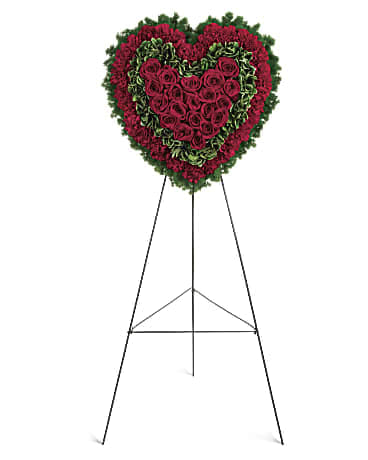 Majestic Heart - Speak from your heart. This majestic funeral display is a charming, heartfelt way to express your love, composed of sympathy red roses and carnations with variegated pittosporum and ming fern. Red carnations, red roses, variegated pittosporum and ming fern are arranged into a touching heart design that's presented on a wire easel. Orientation: One-Sided