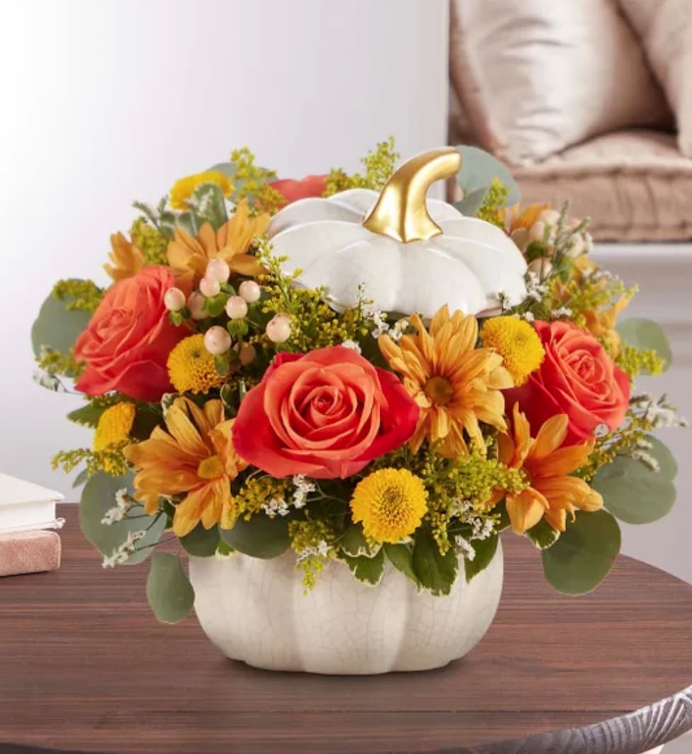 Precious Pumpkin - A plentiful mix of blooms gives our autumn arrangement an undeniable charm. Loosely gathered with pops of orange and yellow, it’s the perfect contrast to our modern-styled pumpkin. Featuring a white satin finish, crackle detail and rich golden accents, this harvest-inspired container is perfect for repurposing.
