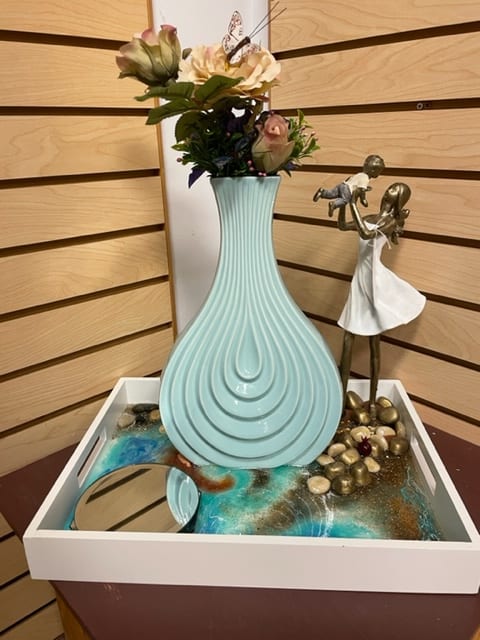 Mother's Joy - Mother's Joy with lady figurine holding child in the air on a tray. With light teal vase with silk flowers.