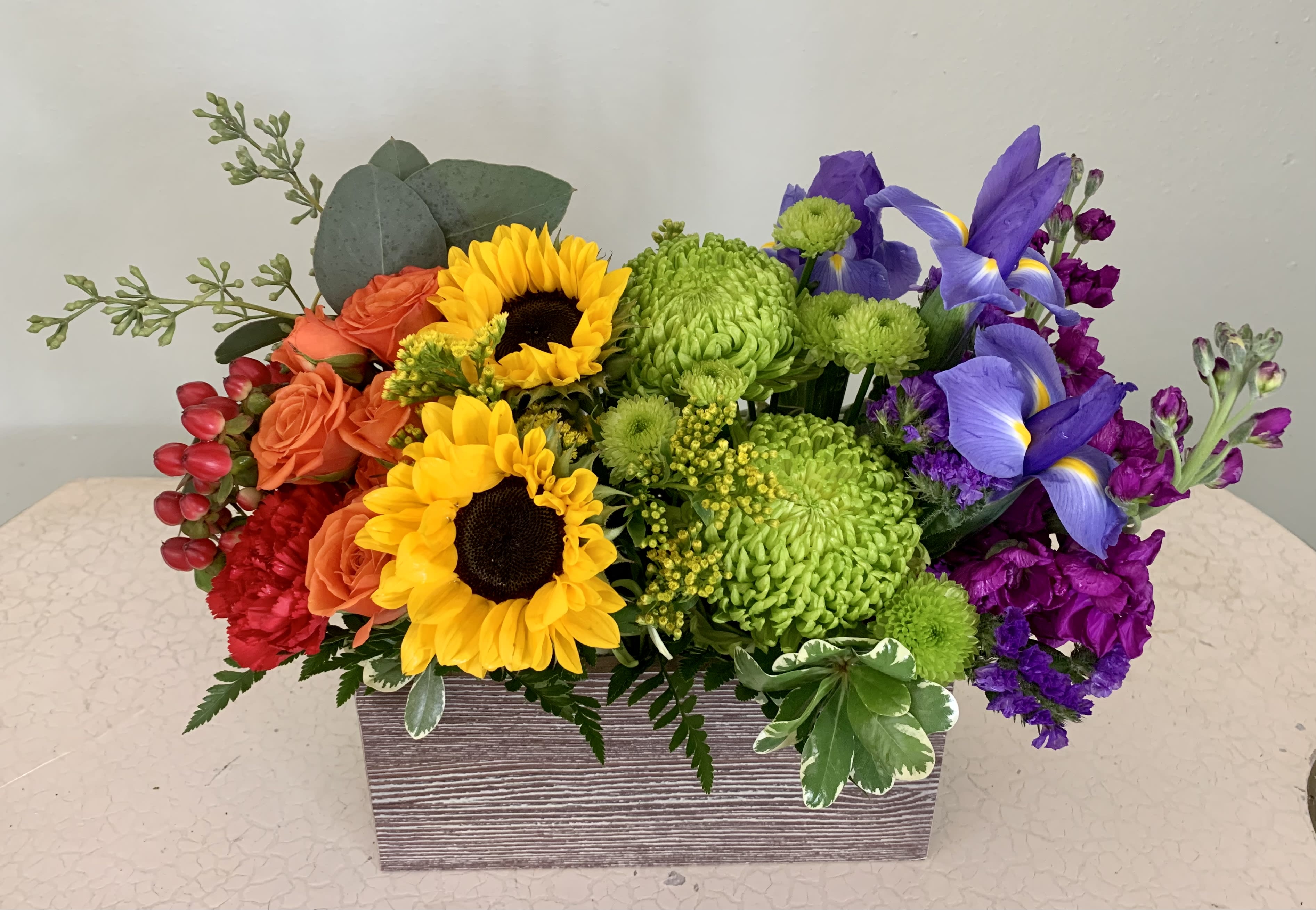 A Twist of Color - A beautiful rainbow of color in a weathered wooden box. A cheerful arrangement for any occasion!