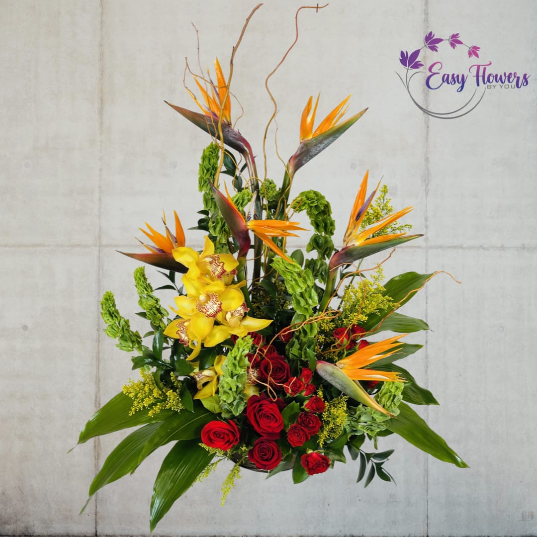 Tropical Celebration - It's a moment to enjoy life's exotic dance, celebrate, be joyful, and have fun. The music that fills the room is made up of yellow cymbidium orchids, birds of paradise, red roses, and tropical vegetation.