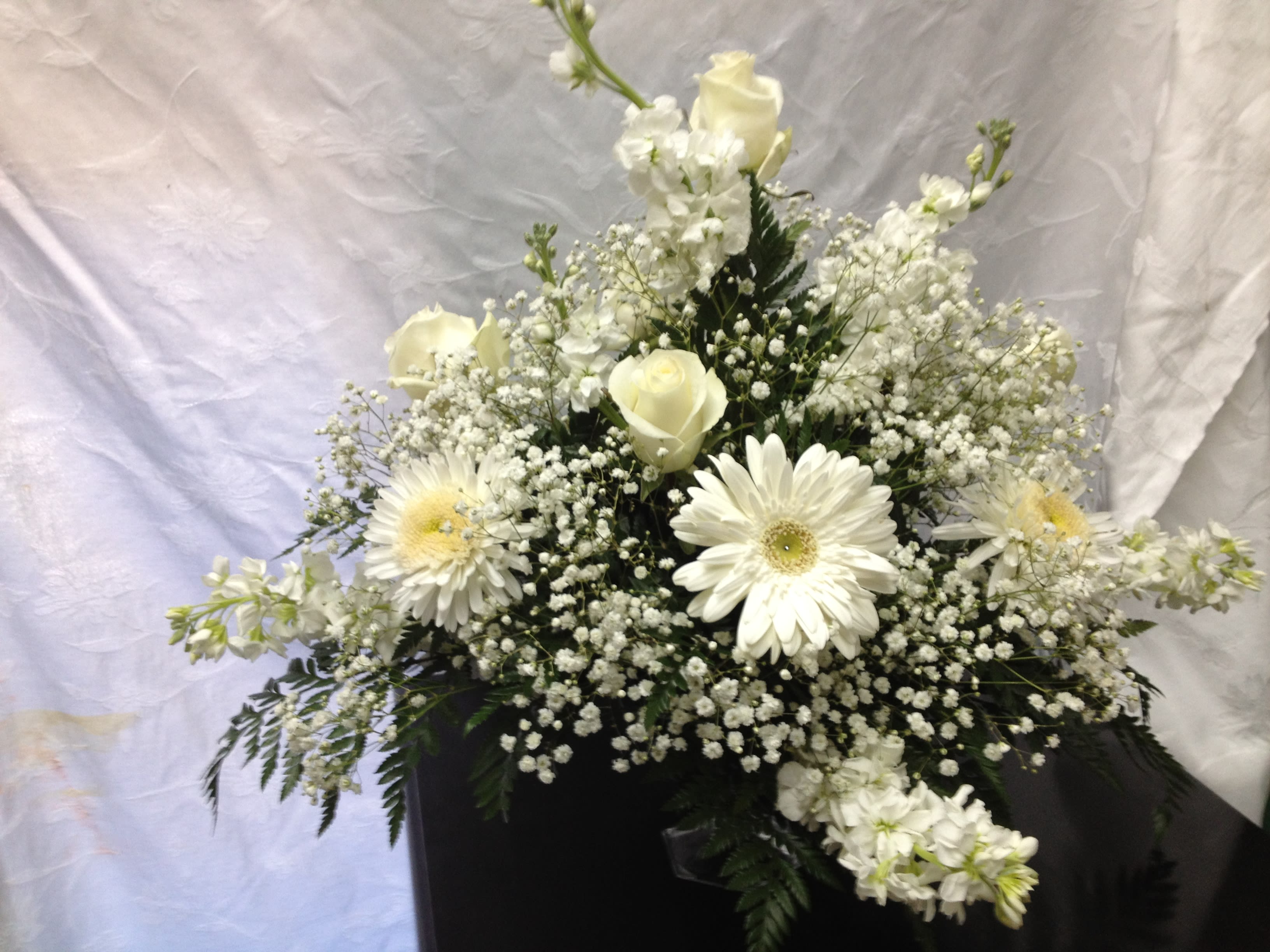 White and Wonderful White and Wonderful - * White roses * White gerbera daisies * White stock * Gyp * Leather leaf * Clear glass dish This full bouquet is romantic and friendly. Give a touch of class to that special someone for a variety of reasons. Let us know if you would like a **box of chocolates to accompany this delivery. ** Additional $15.00