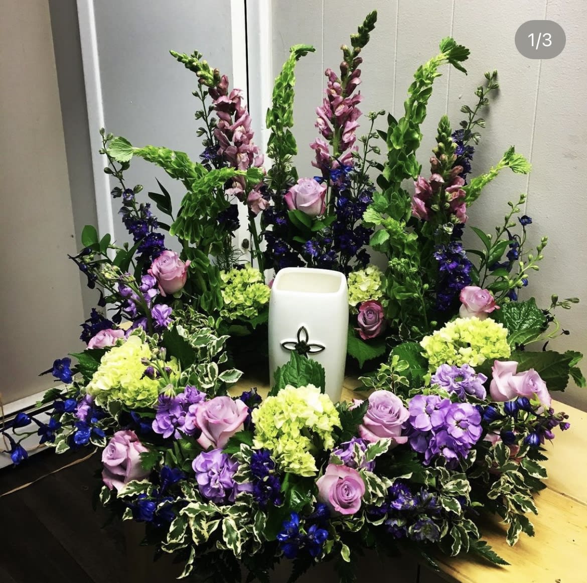 Wreath for a cremation urn - Wreath for a cremation urn in shades of purple ,lavender and green. Assorted seasonal flowers. Each week the selection will be different.