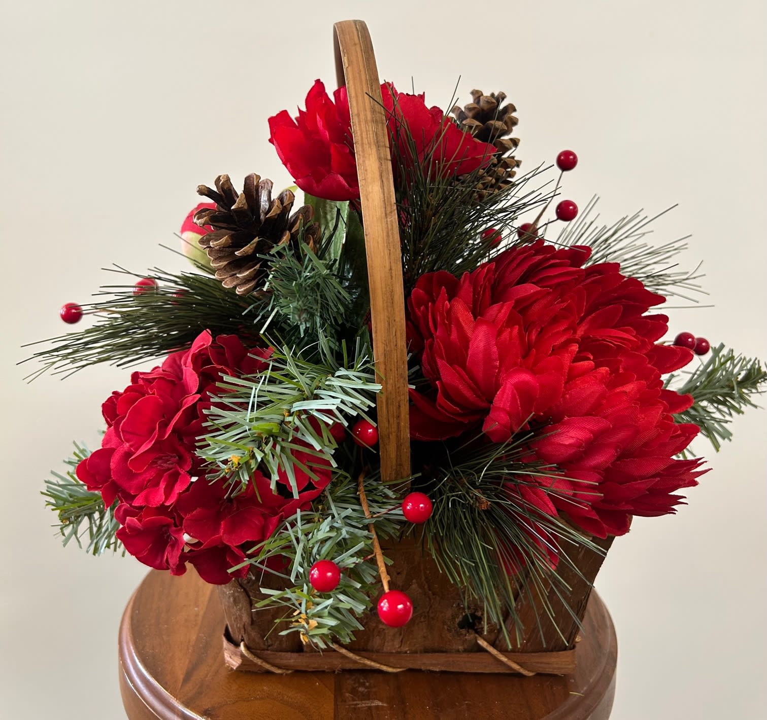 Holiday Silk Arrangement in Bark Basket Holiday Silk Arrangement in Bark Basket - Mixed red flowers with berries, cones, and greens.