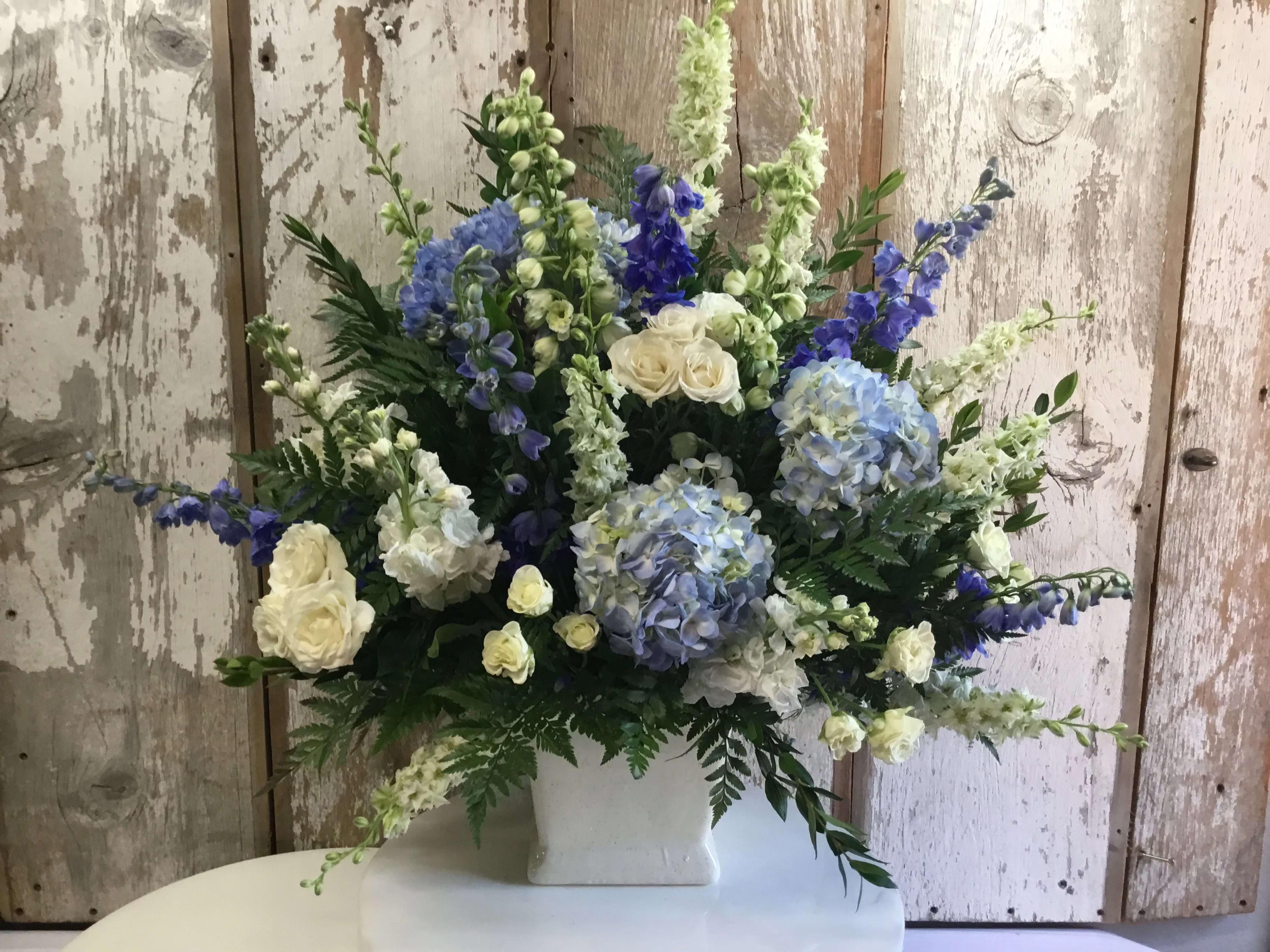 Blue and White Sympathy - Blue Hydrangeas, White Roses, Delphinium and Larkspur in a White Ceramic Planter