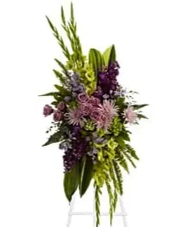 The Endless Sky Spray - A beautiful tropical Spray of soft lavender flowers - roses, fuji chrysanthemums and asters - blended with rich purple stock and other beautiful blooms is this bold floral celebration of life. This stunning standing spray incorporates lush tropical greenery.  Orientation: One-Sided