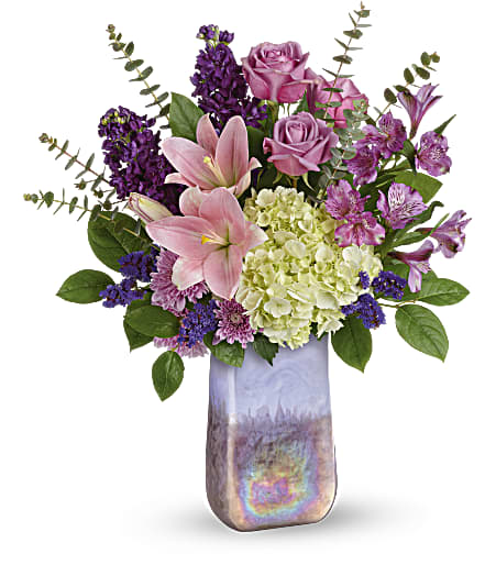 Teleflora's Purple Swirls Bouquet - Truly breathtaking! Swirling with iridescence, this hand-blown, art glass keepsake vase makes a magnificent Mother's Day gift when arranged with elegant hydrangea, roses and lilies.
