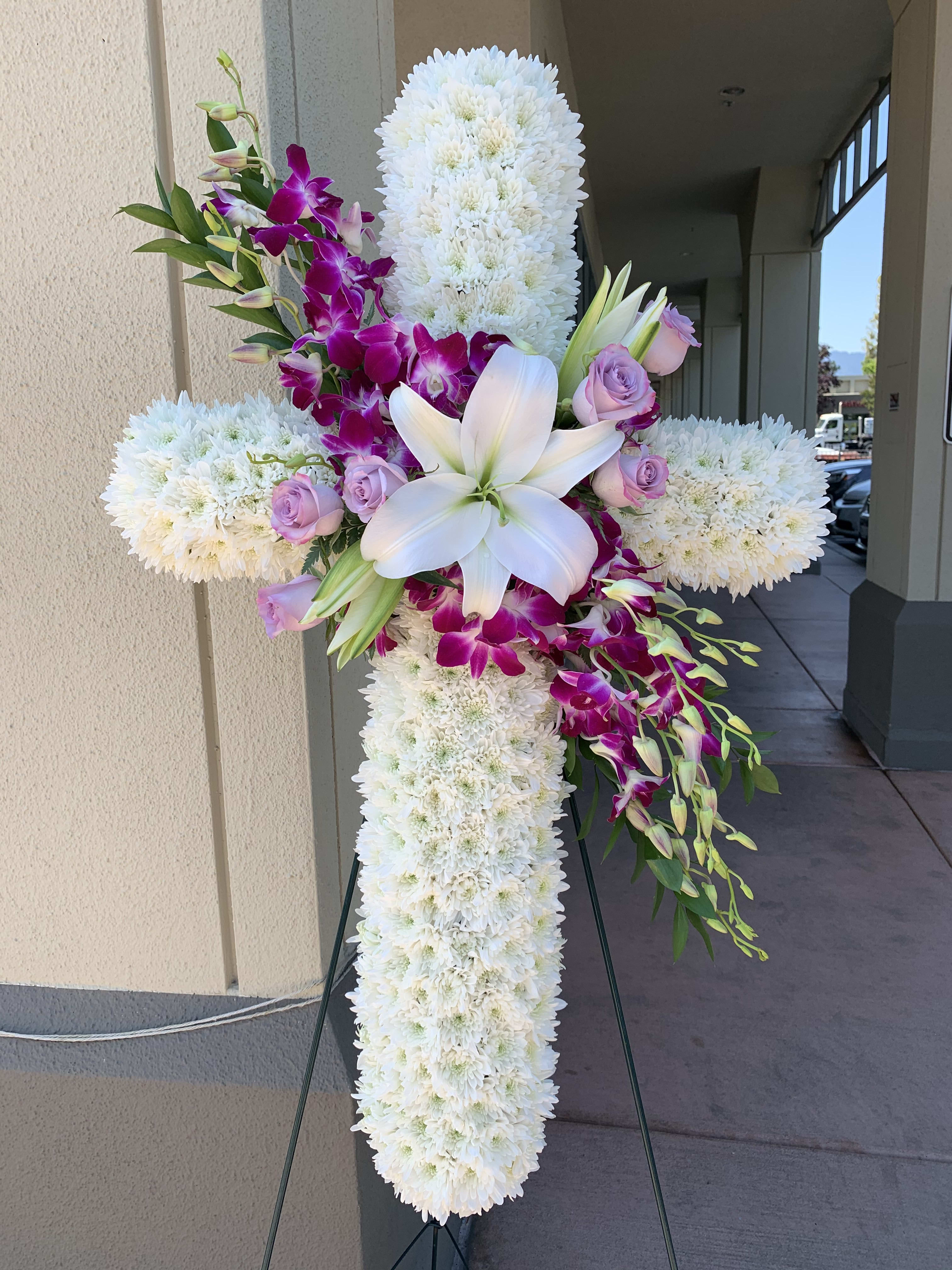 CR#03 Eternal Faith Cross Spray - A cross wreath featuring white chrysanthemums, lilies, roses, dendrobium orchids, and mixed foliage.  Standard: Cross 34&quot; H Deluxe: Cross 40&quot; H (As Shown)