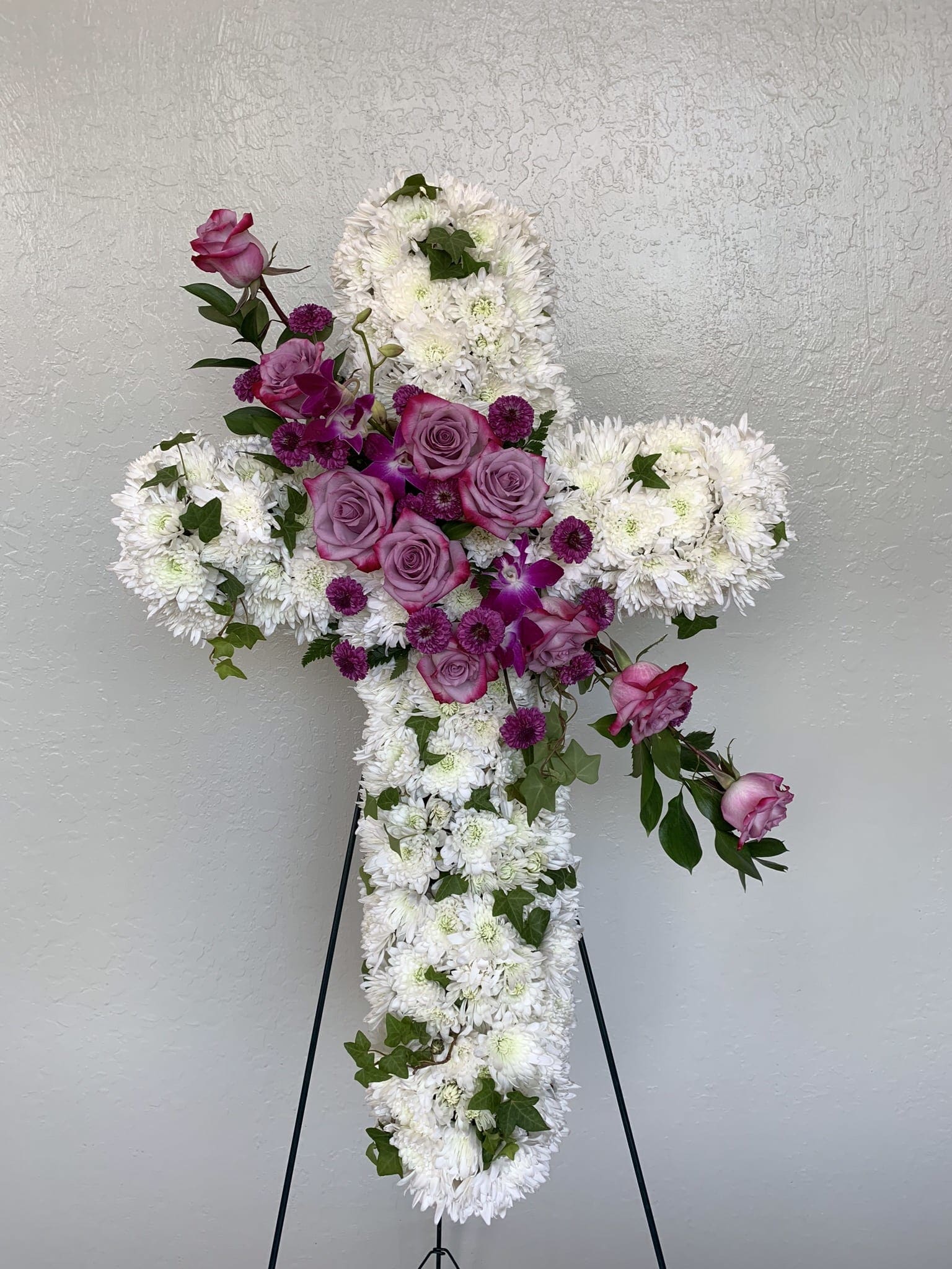 CR#02 Eternal Love Cross Spray  - A cross wreath of white chrysanthemums, purple denrobium orchids and roses, and mixed greens.   Arrangement Dimensions Standard: 34&quot; H  Premium: 40&quot; H
