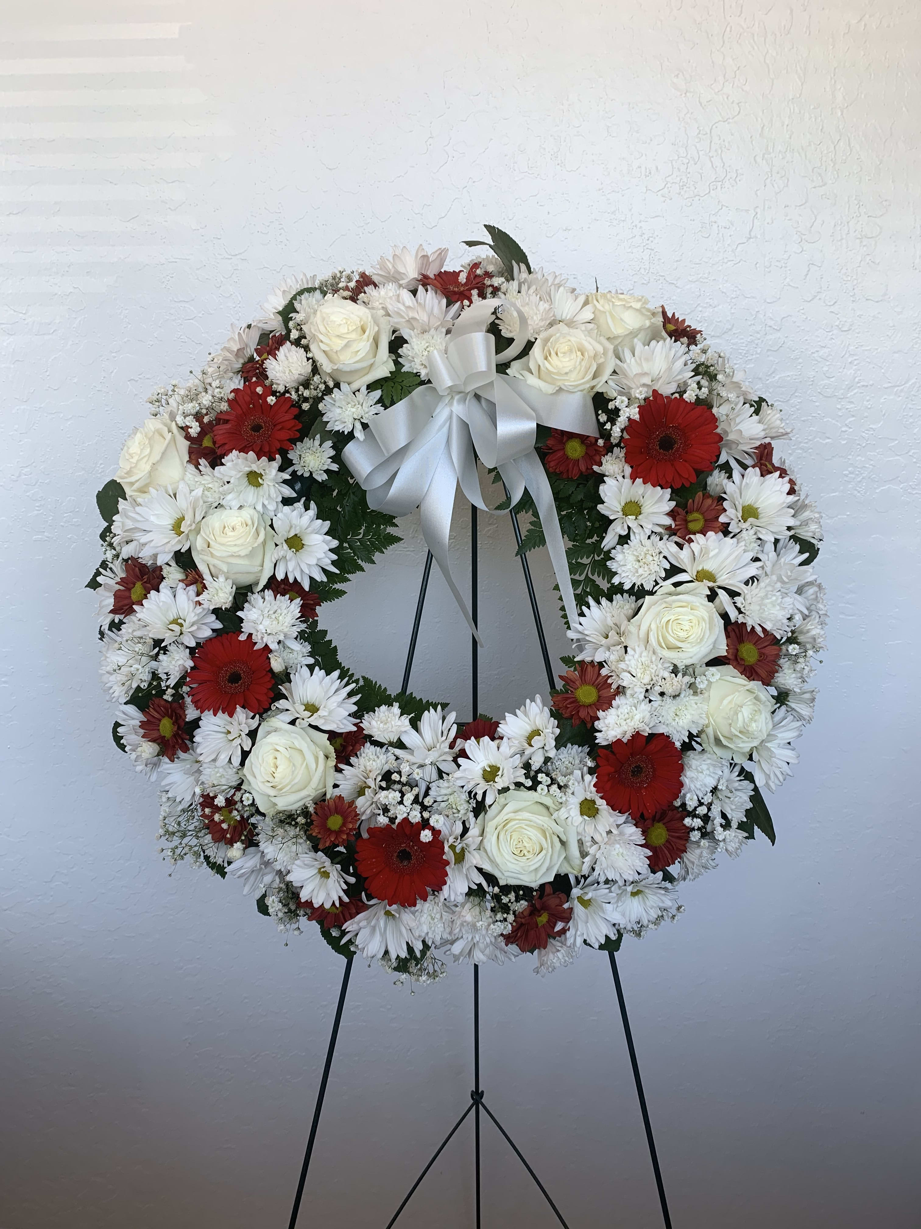 SW#05 Red &amp; White Serenity Wreath - A ring of fragrant, red and white blossoms will create a serene display at any funeral or wake. Delivered on an easel, a standing wreath comprising fresh flowers such as roses, carnations, daisies, chrysanthemums, and mixed foliage.  Standard: 22&quot; diameter (as shown) Deluxe: 26&quot; diameter Premium: 30&quot; diameter