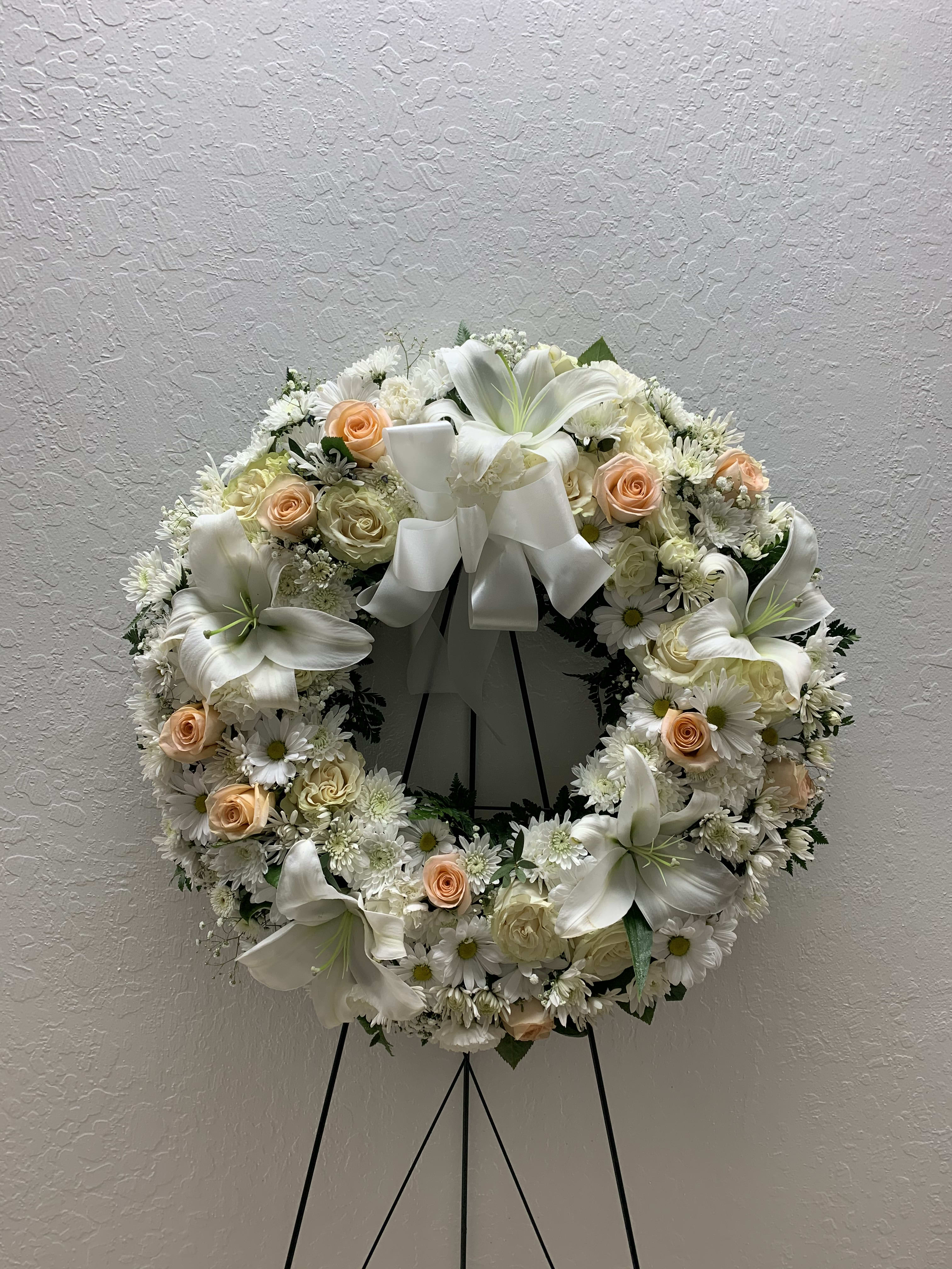 SW#06 Peach &amp; White Serenity Wreath - A ring of fragrant, peach and white blossoms will create a serene display at any funeral or wake. Delivered on an easel, a standing wreath comprising fresh flowers such as roses, lilies, and chrysanthemums, as well as mixed greens.  Standard: 22&quot; diameter Deluxe: 26&quot; diameter (as shown) Premium: 30&quot; diameter