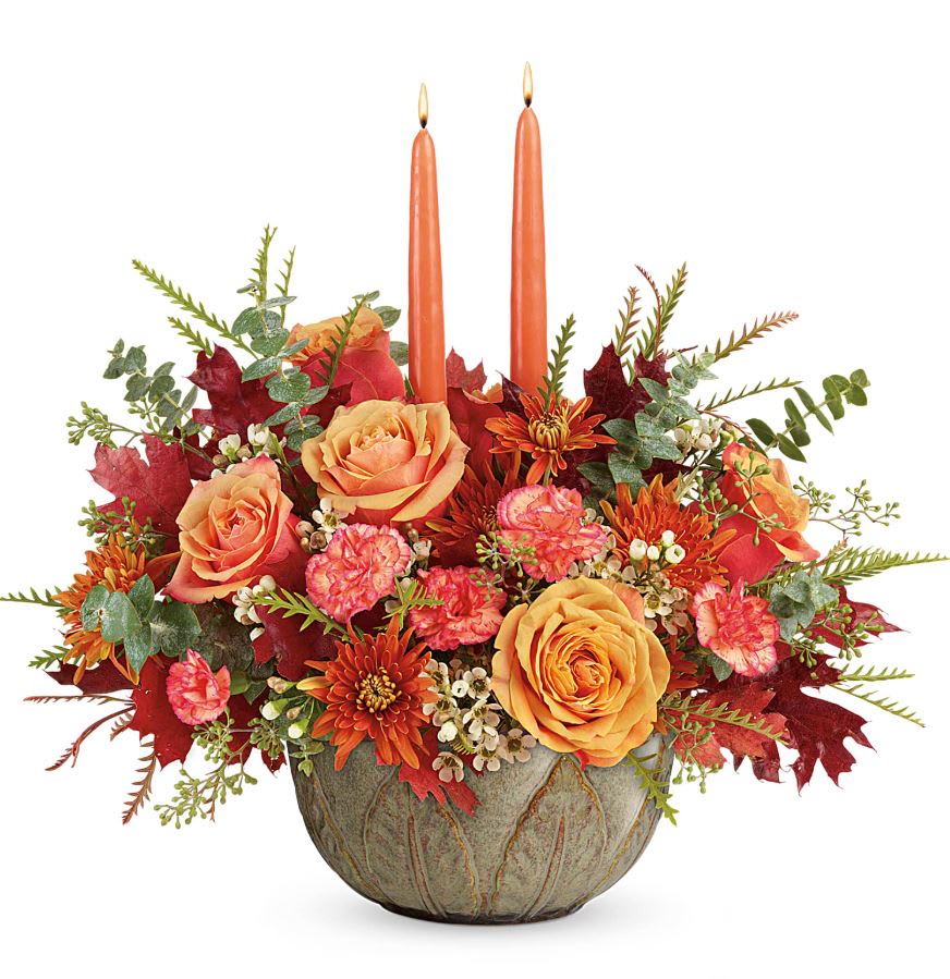 Teleflora's Artisanal Autumn Centerpiece - Two fall favorites in one gorgeous gift! This glorious autumnal rose bouquet with glowing tapers, arranged in a hand-glazed stoneware serving bowl, brings artisanal beauty to any fall celebration.  Light orange roses, orange miniature carnations, and bronze cushion spray chrysanthemums are accented with white waxflower, spiral eucalyptus, grevillea, seeded eucalyptus, brown transparent oak leaves, and two peach candles. Delivered in an Artisanal Autumn Bowl. Approximately 17 1/2&quot; W x 15 1/2&quot; H 