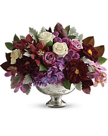 Teleflora's Beautiful Harvest Centerpiece - Take your fall décor to a sophisticated new level with this breathtaking bouquet of deep purple blooms, presented in a timelessly elegant mercury glass bowl. This lush arrangement features purple hydrangea, red cymbidium orchids, purple mokara orchids, crème roses, lavender roses, burgundy dahlias, purple button spray chrysanthemums, magnolia leaves, dusty miller, burgundy copper beech, and lemon leaf. Delivered in Teleflora's Mercury Glass Bowl.
