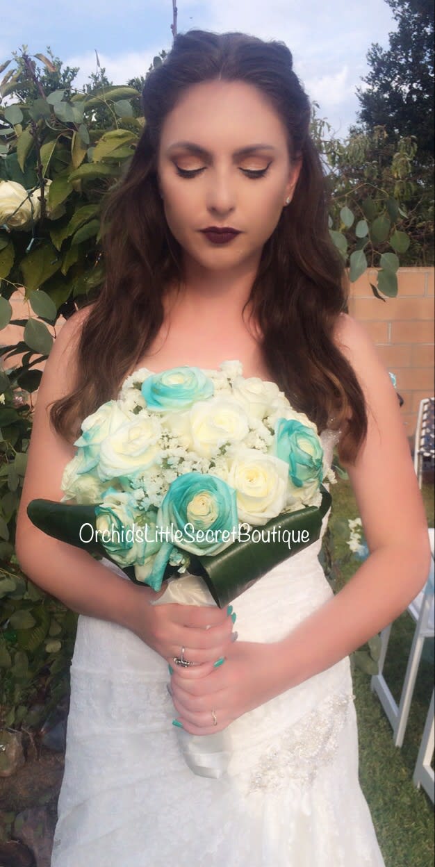 Ariel Bride Bouquet Turquoise  - White Rose Bouquet features dyed splashed turquoise roses per the Brides request, accented with other blooms and tropical greens.