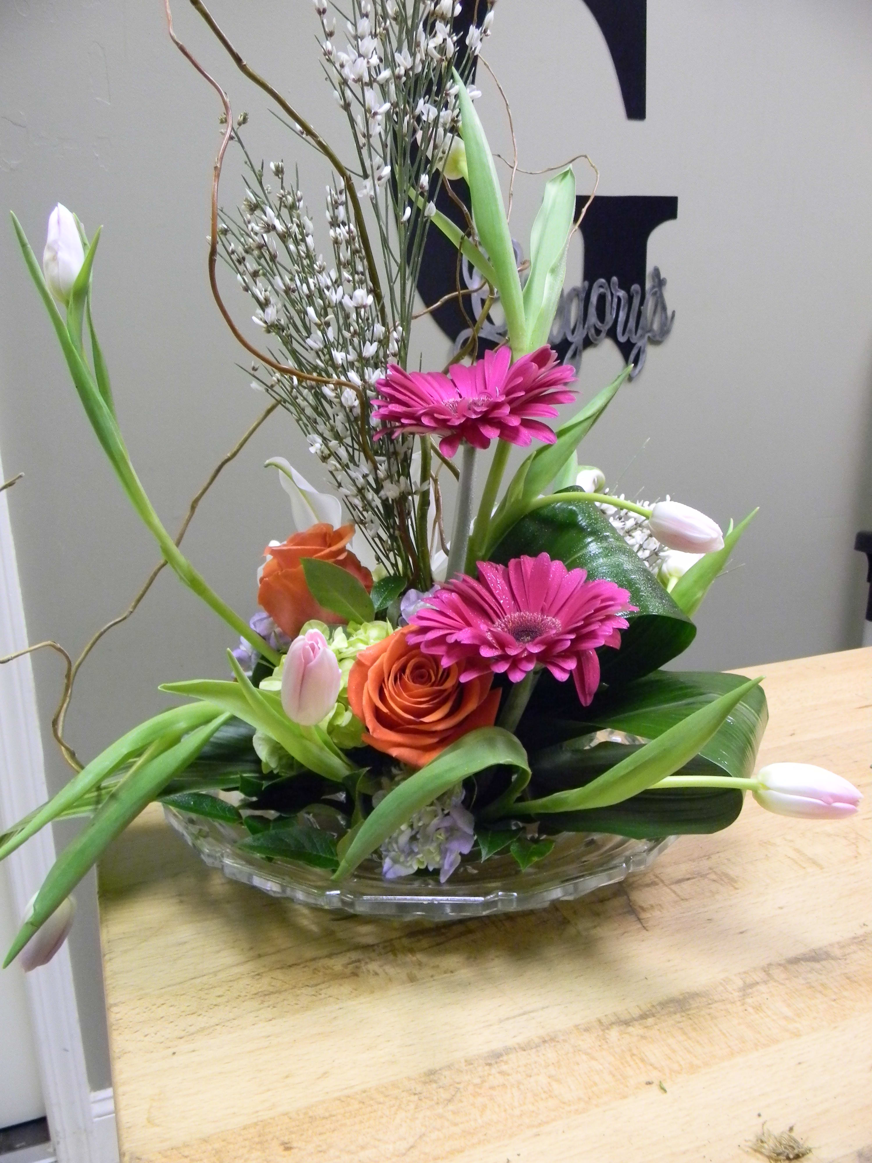 Gerbera Daisy Bowl Gerbera Daisy Bowl - A shallow bowl designed in a contemporary style with gerbera daisys, hydrangea, tulips and curly willow