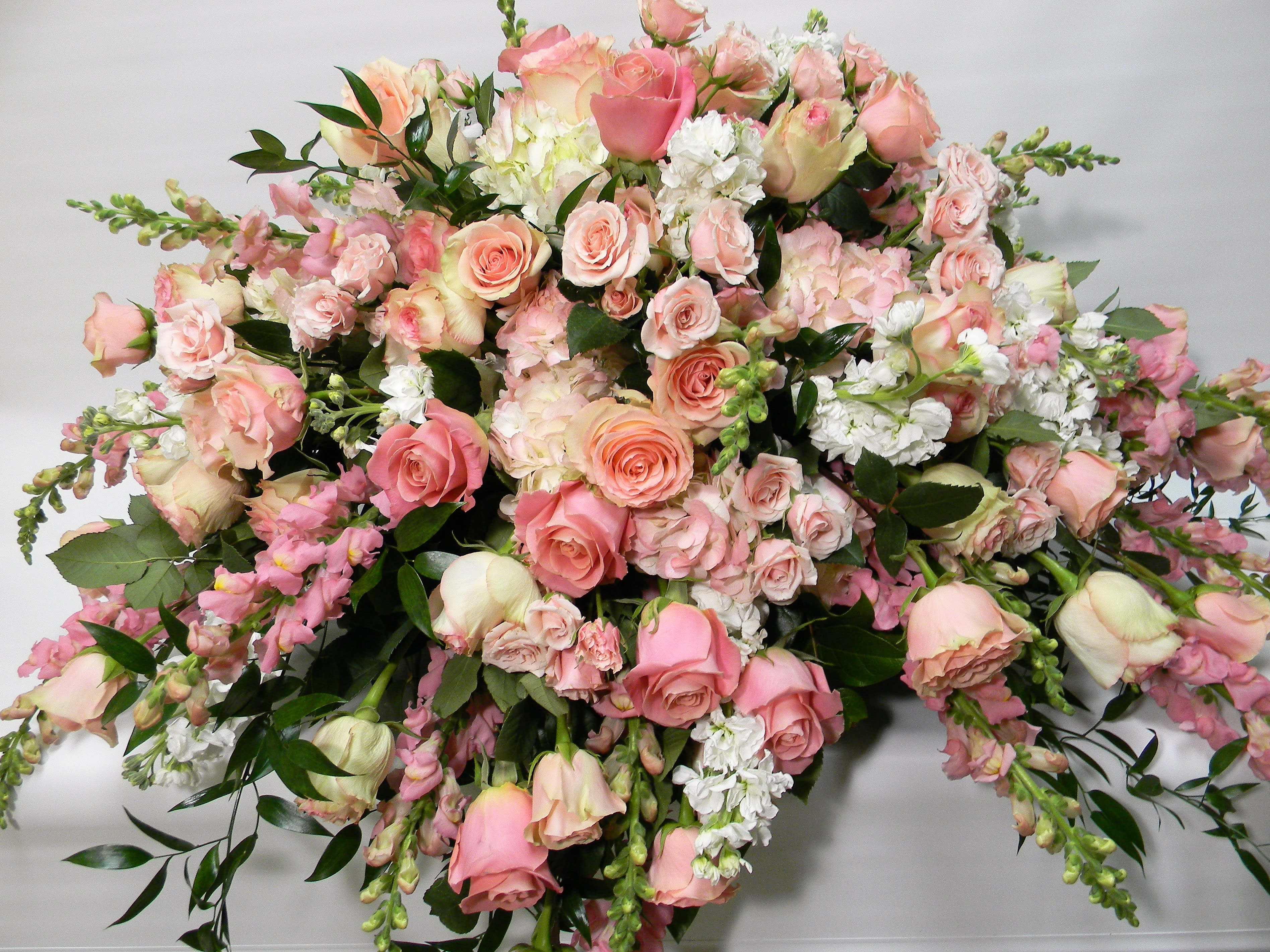 Memorial in pink Memorial in pink - Casket spray of pink roses, snap dragons and white stock