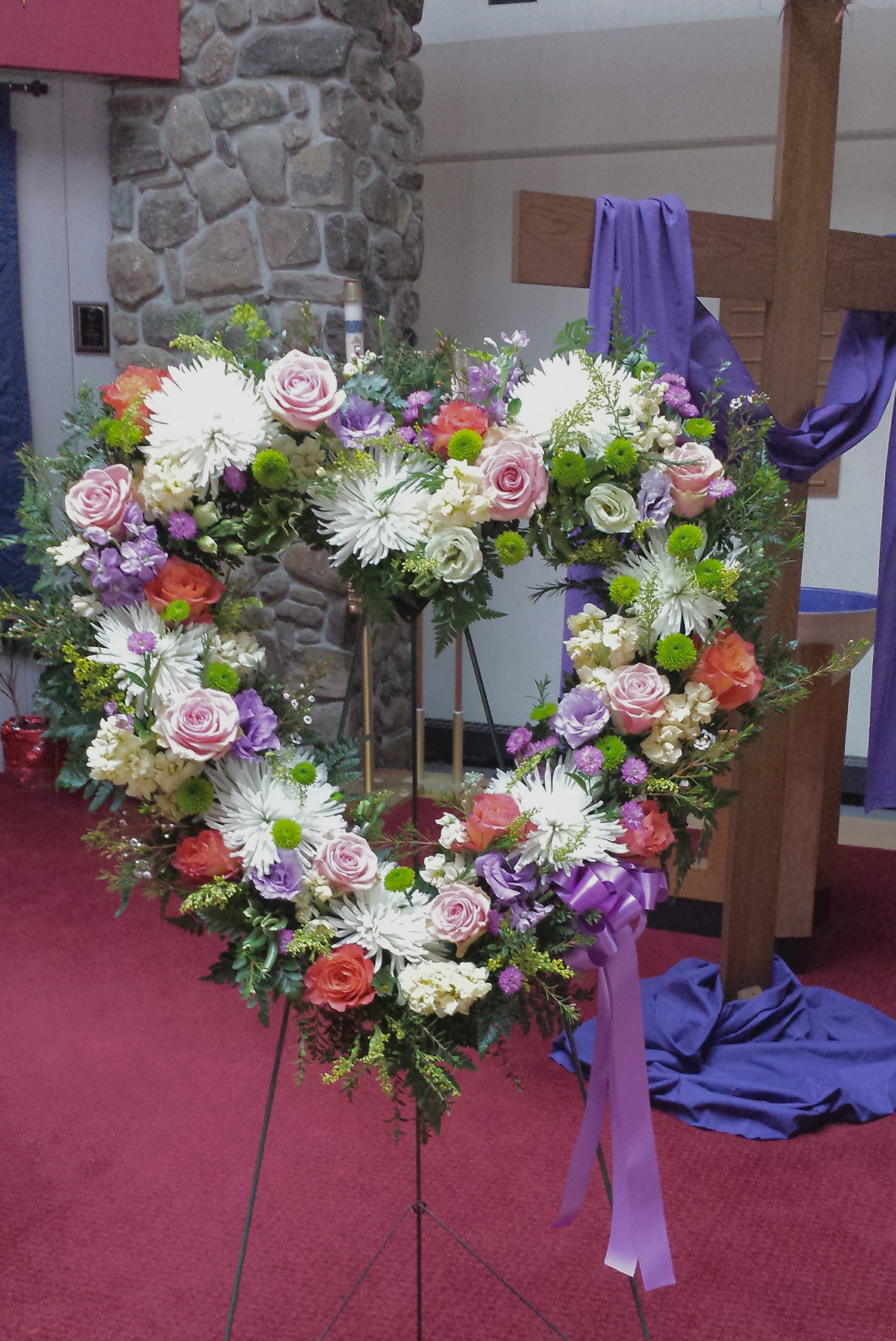 Floral heart truibute - This heart shaped wreath is abundant in  its sentiment and  delicate pastel colored blooms . Very few words required with this display. 