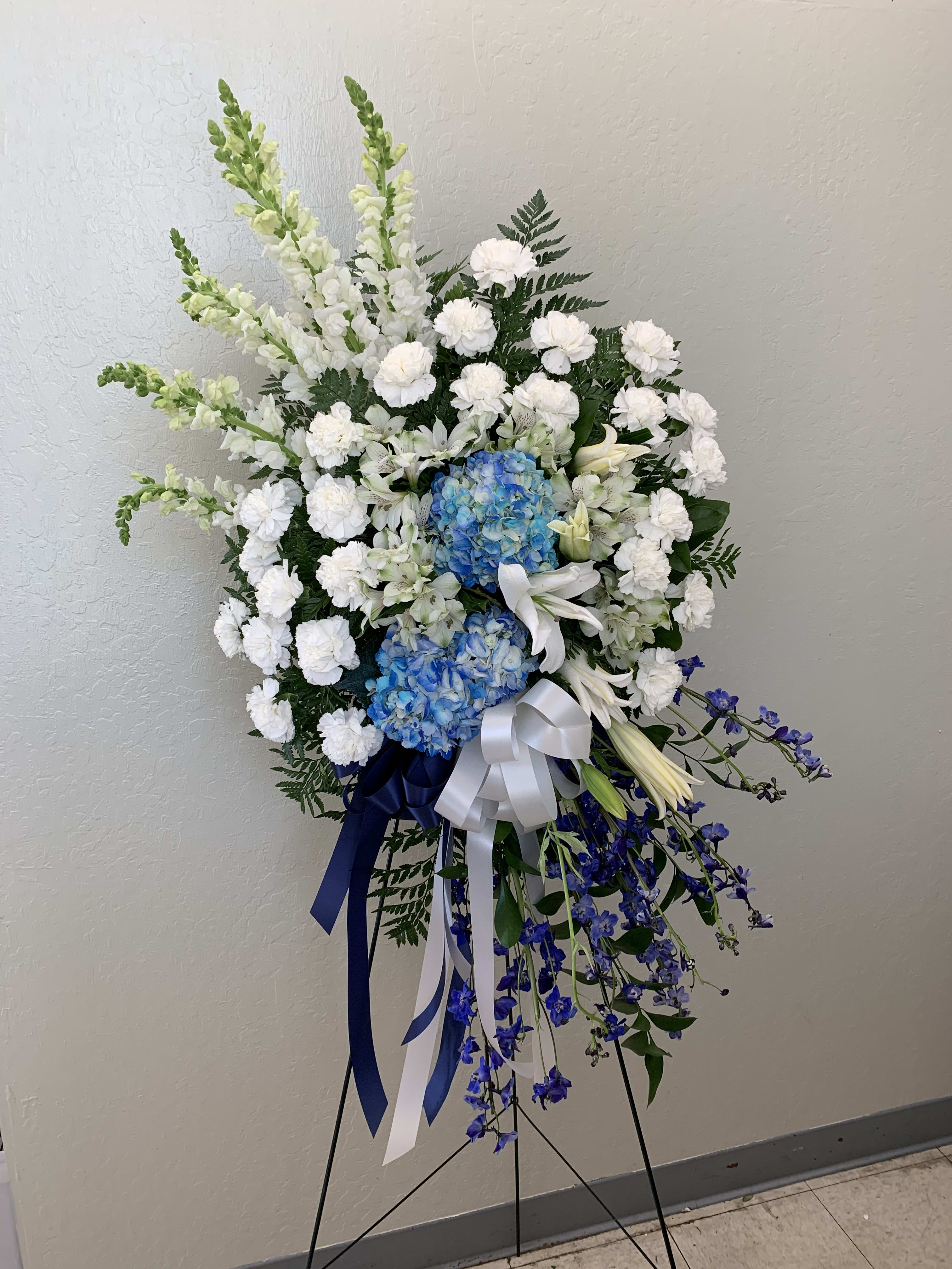 SS#11 Ethereal Blues Spray - A beautiful blue and white spray, an ethereal glow much like the skies. This spray features lilies, hydrangeas, carnations, alstroemerias, snapdragons, delphinium, and mixed foliage.  The arrangement is approximately 48&quot; H and 24&quot; W.