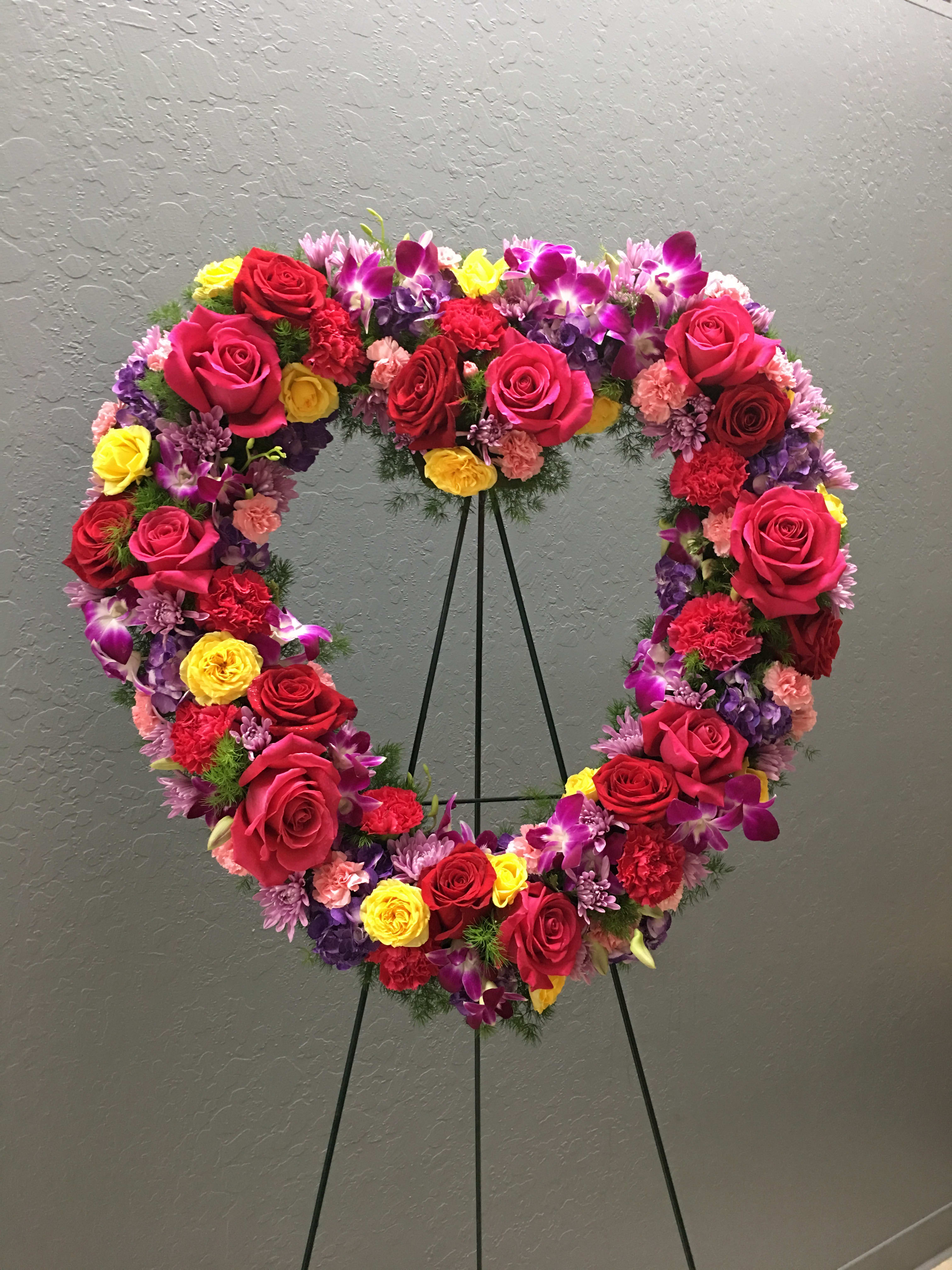 GH#04 Radiant Garden Heart - Radiate the atmosphere with this colorful and bright garden heart featuring roses, carnations, dendrobium orchids, hydrangeas, spray roses, pom poms, and mixed foliage.  Standard: 20&quot; W x 20&quot; H Deluxe: 24&quot; W x 24&quot; H Premium: 28&quot; W x 28&quot; H (as shown)