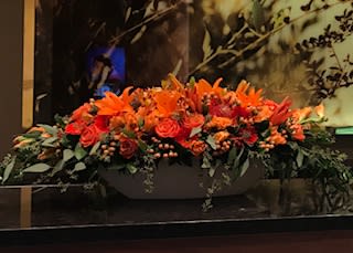 Autumn Beauty GRANDE - A fresh flower arrangement for autumn is created with luxury premium flowers roses, alstroemeria, chrysanthemums, tulips, lilies, gladiolas, pin cushion proteas, hypericum, greens, and filler in a large white ceramic vase measuring 25 inches long by 9.5 inches high.