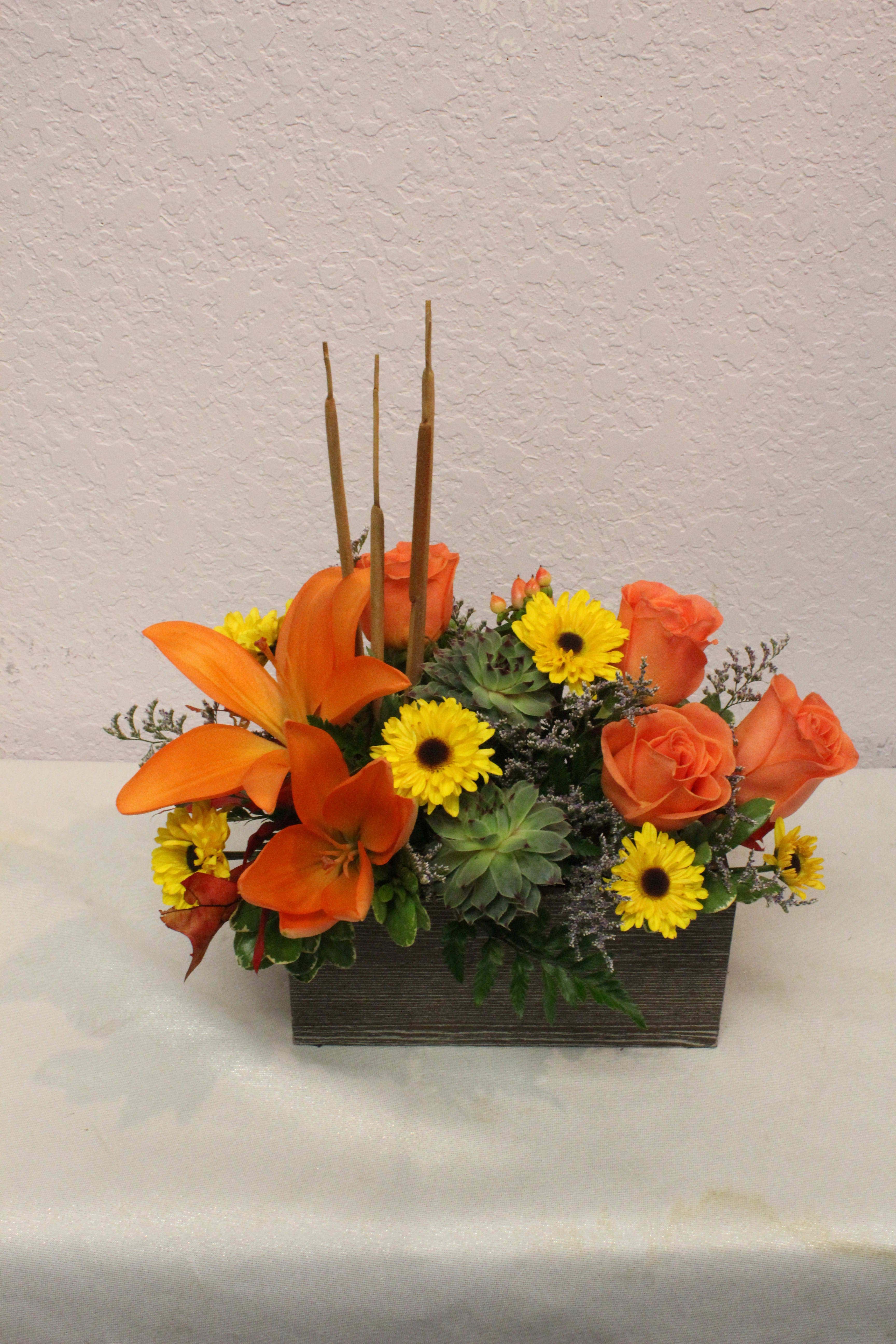 CFF103 - A mixed fall arrangement in of Lilies, Roses, Daises &amp; Succulents arranged in a square cube. 