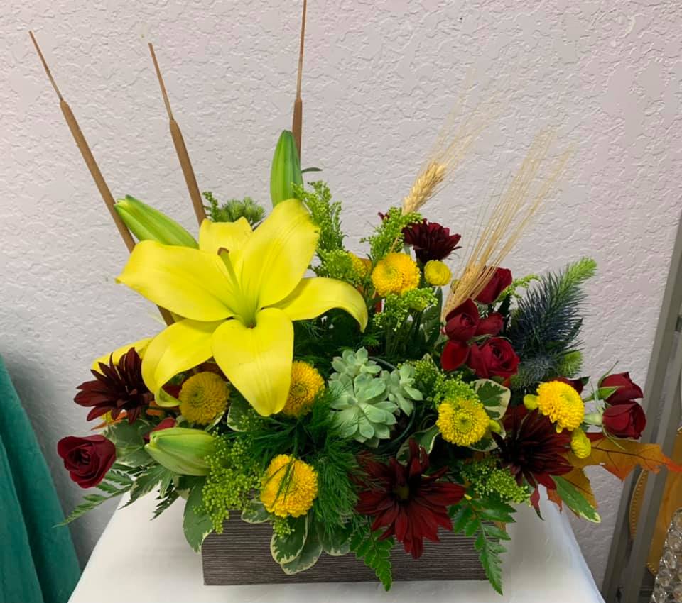 CFF111 CFF111 - A beautiful compact fall mixed arrangement in a square with flowers such as lilies, roses, mums, mixed greenery and other fall accents.