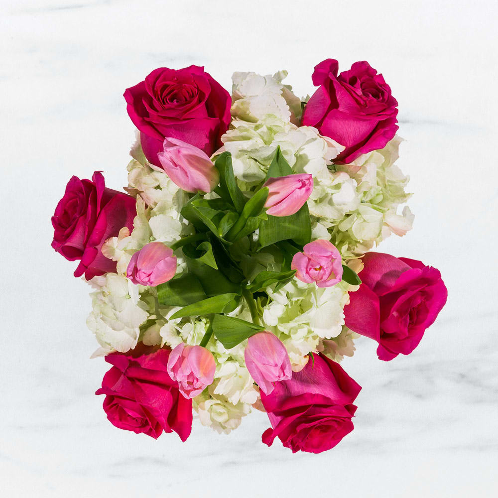 Fun &amp; Flirty by BloomNation™ - This cheerful bouquet brings lighthearted fun to any occasion. Fun &amp; Flirty by BloomNation™ is the perfect gift to wish someone a happy birthday or to say thank you.   Arrangement Details: Includes hot pink roses, pink tulips, and white hydrangea. APPROXIMATE DIMENSIONS: 12&quot; H X 11&quot; W 