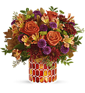 Autumn Radiance  - This radiant arrangement includes orange roses, light orange alstroemeria, purple button spray chrysanthemums, burgundy cushion spray chrysanthemums, bupleurum, seeded eucalyptus and huckleberry, accented with transparent oak leaves. Delivered in Teleflora's Autumn Radiance Mosaic vase. Approximately 13 3/4&quot; W x 12 1/2&quot; H Radiant roses and lush fall blooms are presented to perfection in a keepsake mosaic vase of stunning stained glass. 