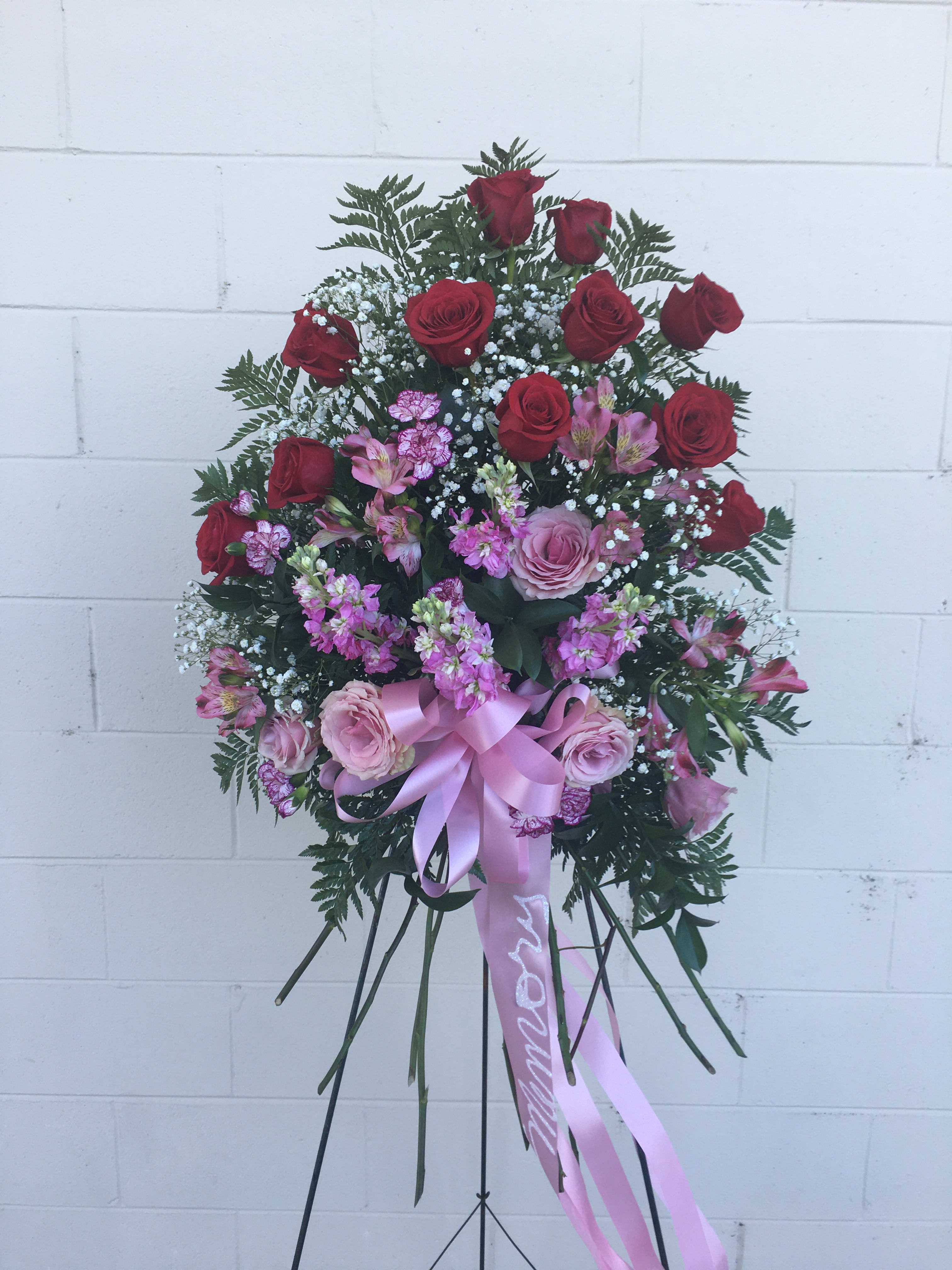 Rose Standing Spray. - Red and pink rose with ,alstroemeria, mini carnations, stock and a background or greenery.