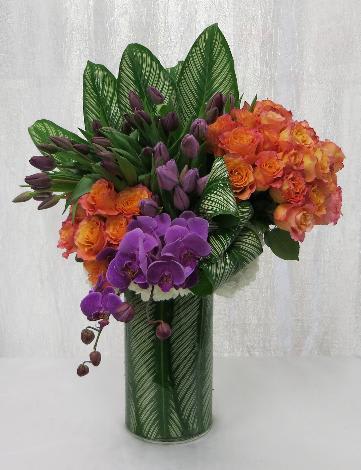 Tropical Tulips Sherbert Orange Roses and Orchids - Orange Sherbert Roses, Purple Tulips and Fuchsia Orchids come together to create a bright and chic arrangement reminiscent of a tropical sunset. 