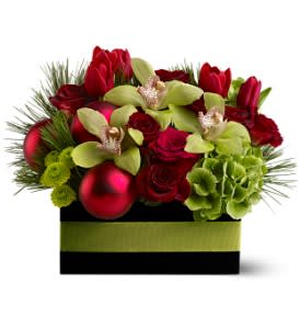 Holiday Chic - A mix of elegant blossoms such as roses, orchids and hydrangea in shades of bold red and pale green is arranged with gleaming red ornament balls in a ribbon-trimmed wooden box. A true display of holiday chic!  A mix of fresh flowers such as cymbidium orchids, roses, hydrangea and tulips – in shades of red and green – is arranged in a wooden box with red ornament balls and a green ribbon.  Approximately 12&quot; (W) x 11&quot; (H)  Orientation: All-Around  As Shown : TFWEB272