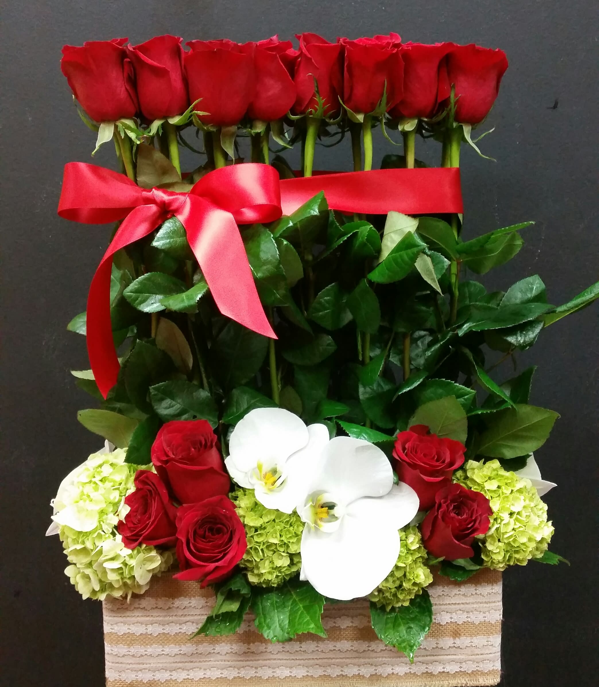 Celebrate your special day  - 2dozen red roses in the vintage look container with supporting flowers added