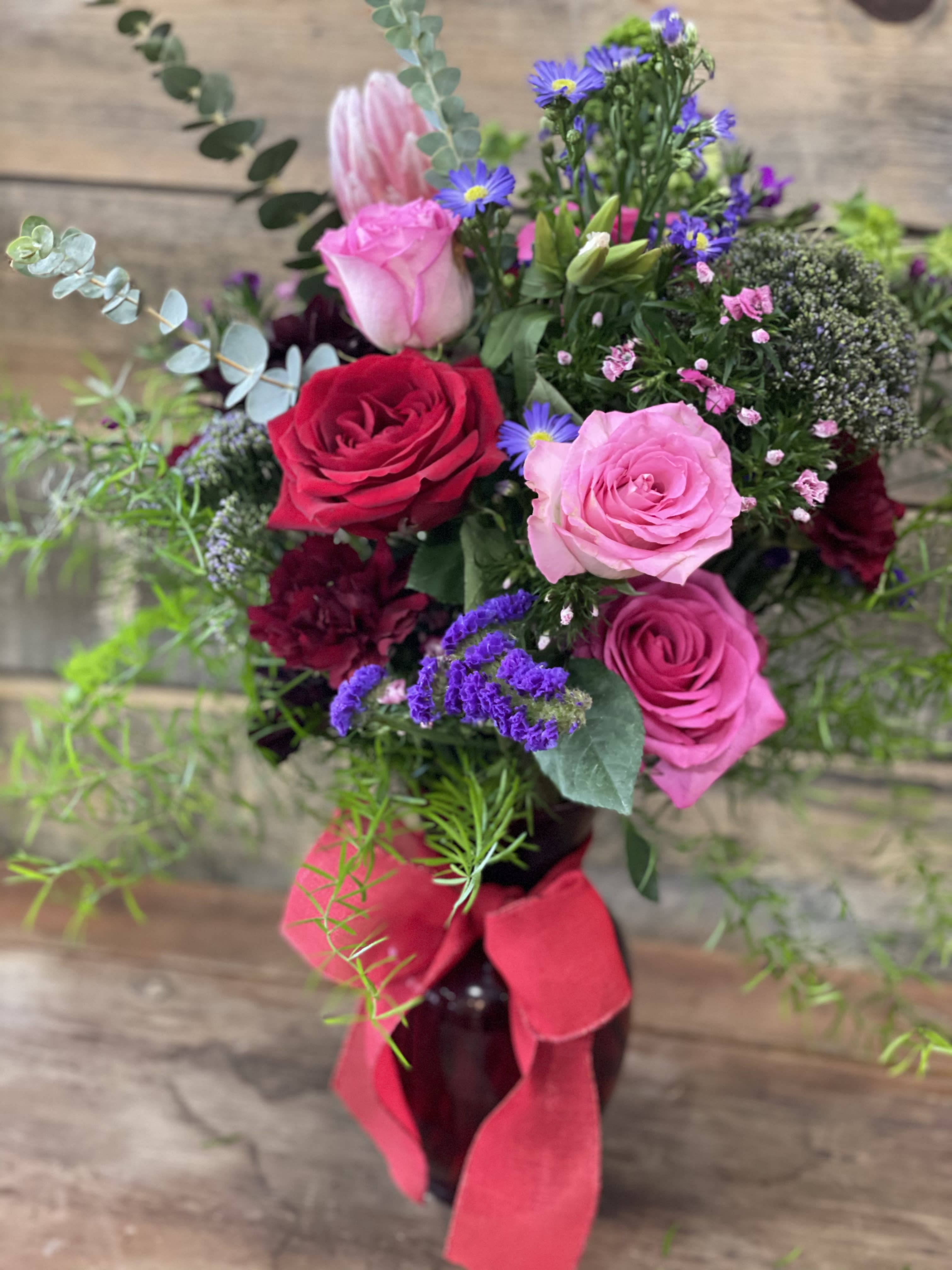 All about Love - A mixed, bright bouquet with a selection of interesting greens. 