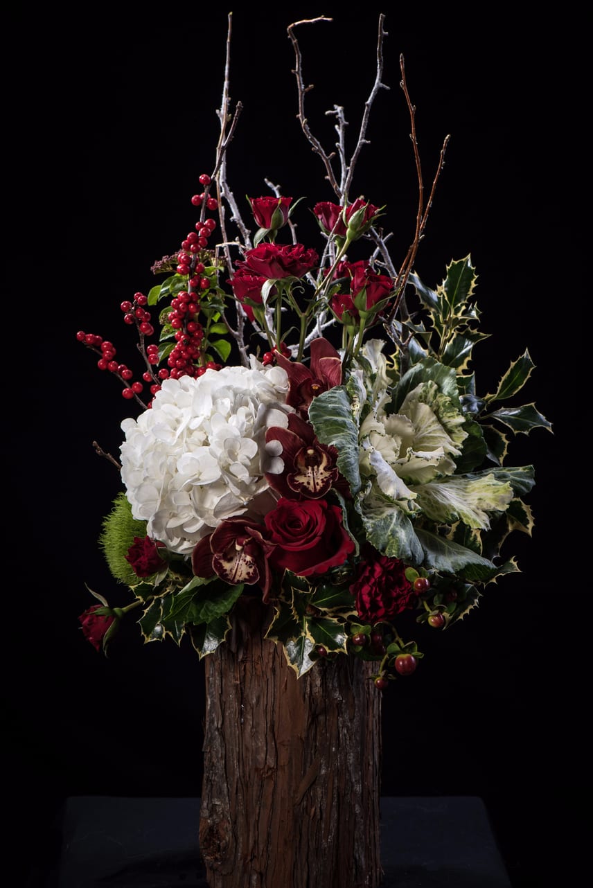 Jolly Tree - A holiday arrangement composed of hydrangeas, orchids, spray roses, roses, kale, huckleberries, berries, flocked branches, variety of greens. 
