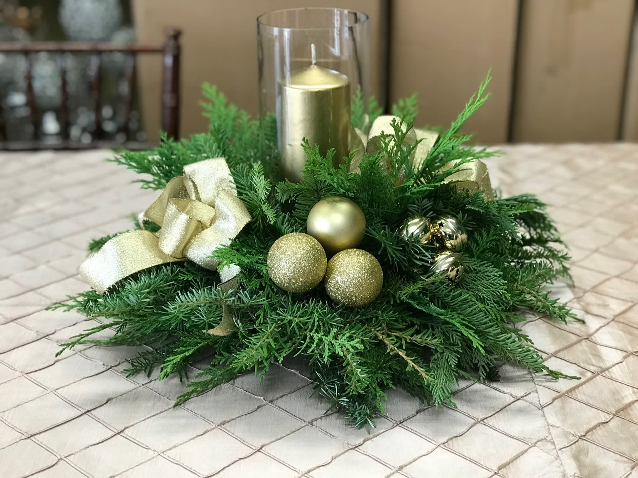 Christmas Gold Centerpiece  - Christmas Greens featuring a gold candle, ornaments and decor. Can be done in other colors is desired. 
