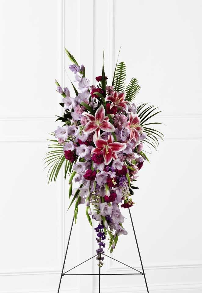 The FTD Tender Touch Standing Spray - The FTD Tender Touch Standing Spray creates an elegant display of beauty and color to enhance their final tribute. Lavender gladiolus, Stargazer lilies, fuchsia carnations, purple larkspur, lavender Peruvian lilies, lavender chrysanthemums, sword fern fronds, emerald palm fronds and other assorted greens are gorgeously arranged to create a sophisticated standing spray. Displayed on a wire easel, this arrangement will add to the sophistication of their service with each fragrant bloom.