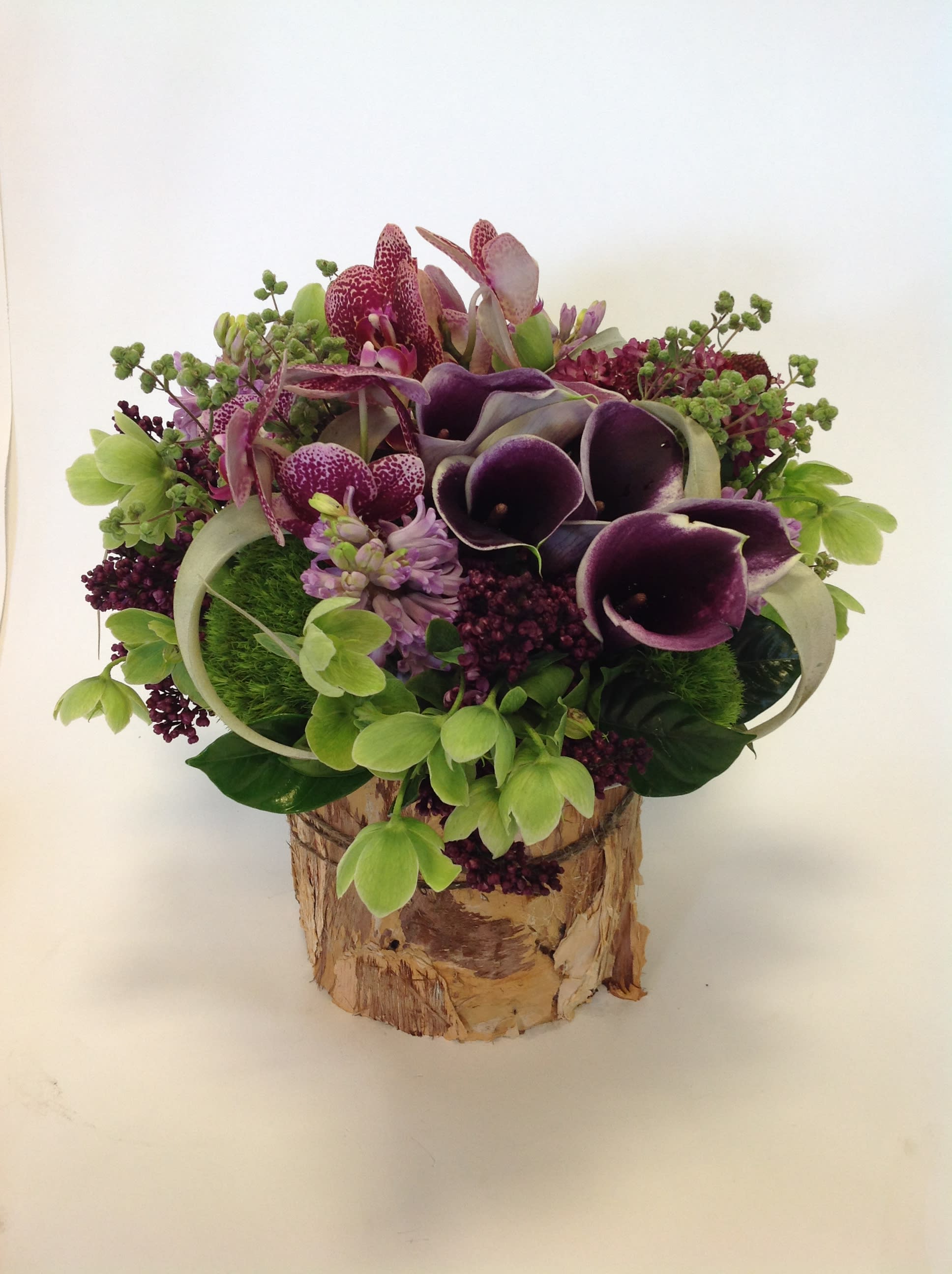 Earthy Prince - Breathtaking and stunning is the only way to describe this arrangement. A mixed bouquet of Calla lilies, Hyacinths, Orchids and Dianthus. The unique vase only adds to its beauty.  
