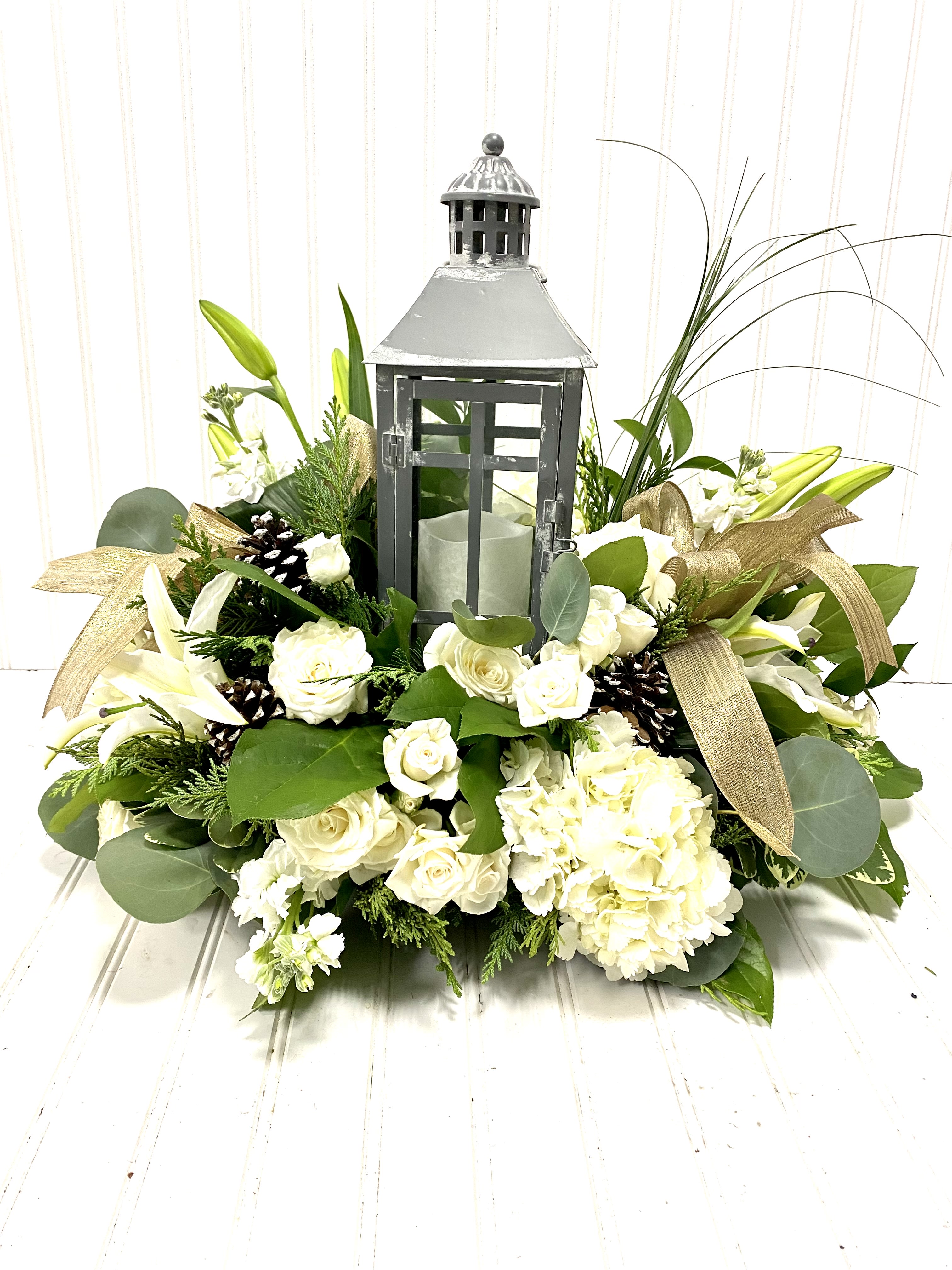 Light the Way - White - A nice simple arrangement including a lighthouse with beautiful white blooms. It is perfect to adorn as a centerpiece OR even find comfort as a sympathy piece. 