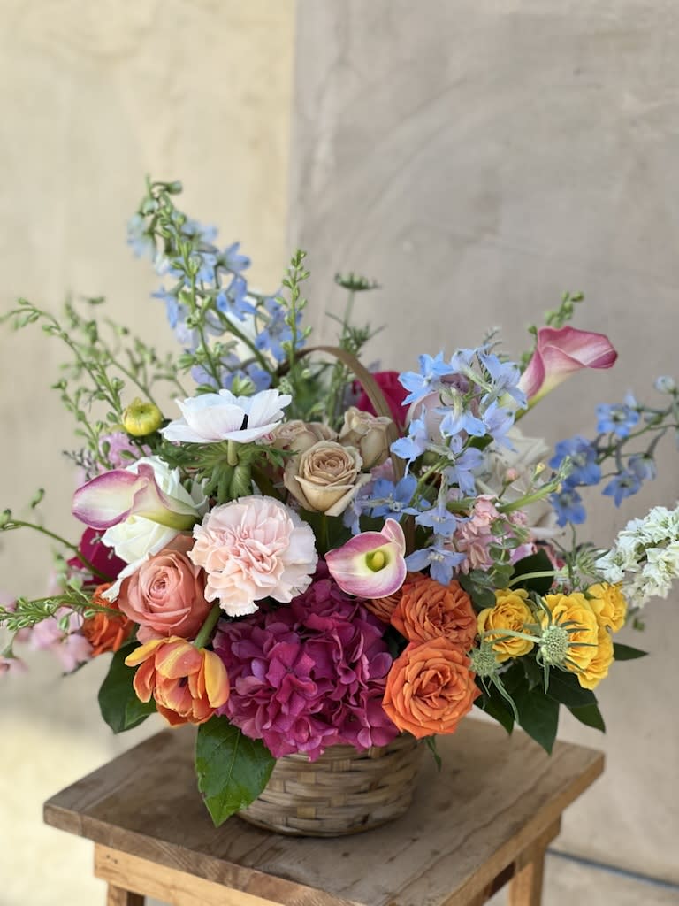 Autumn Basket - Send a basket full of beautiful seasonal flowers with hydrangeas, tulips, roses, calla lilies, and blue delphinium.