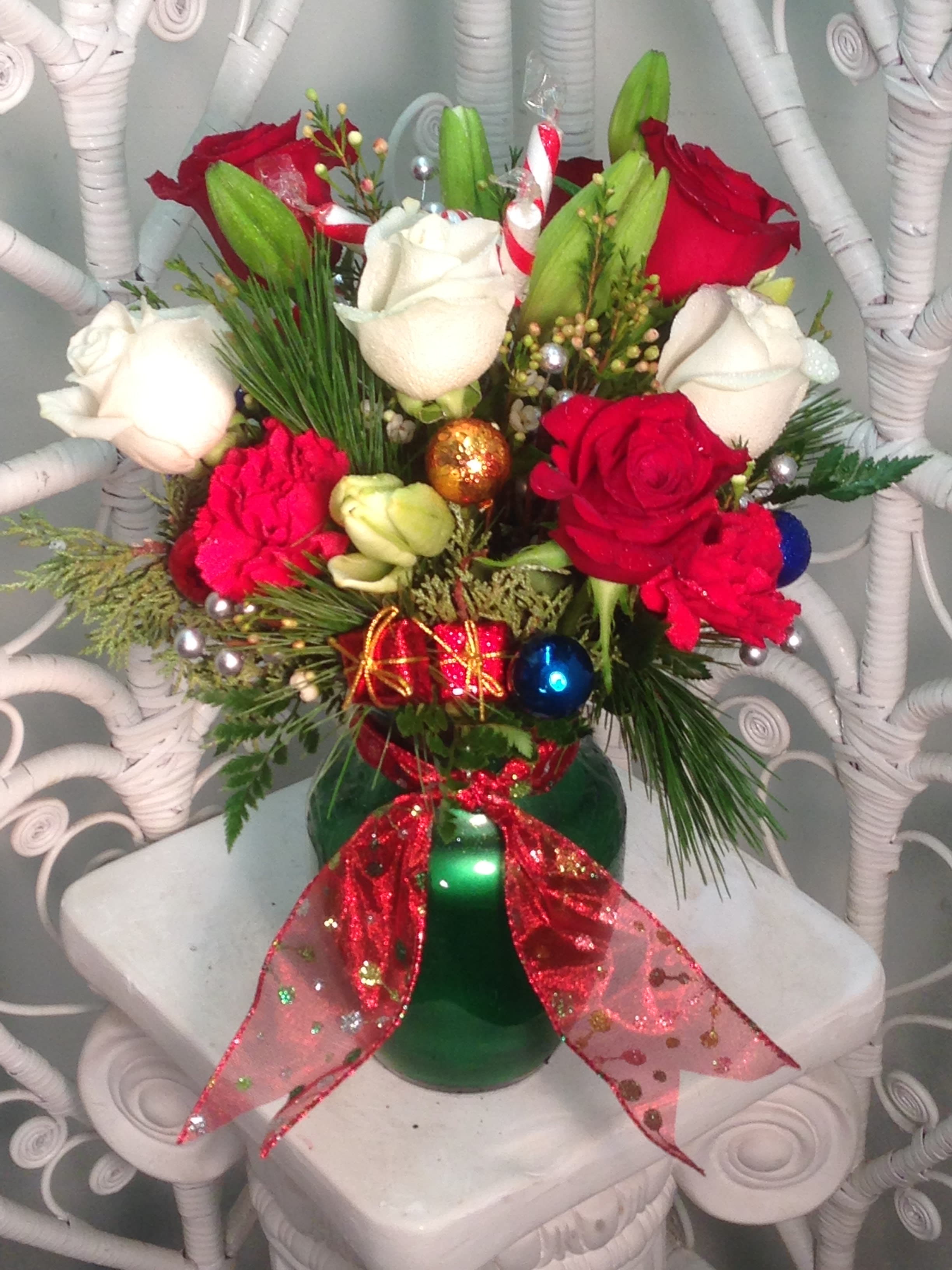 Festive Christmas  - Red and white roses, lilies and carnations arranged with seasonal greens and plenty of holiday cheer!